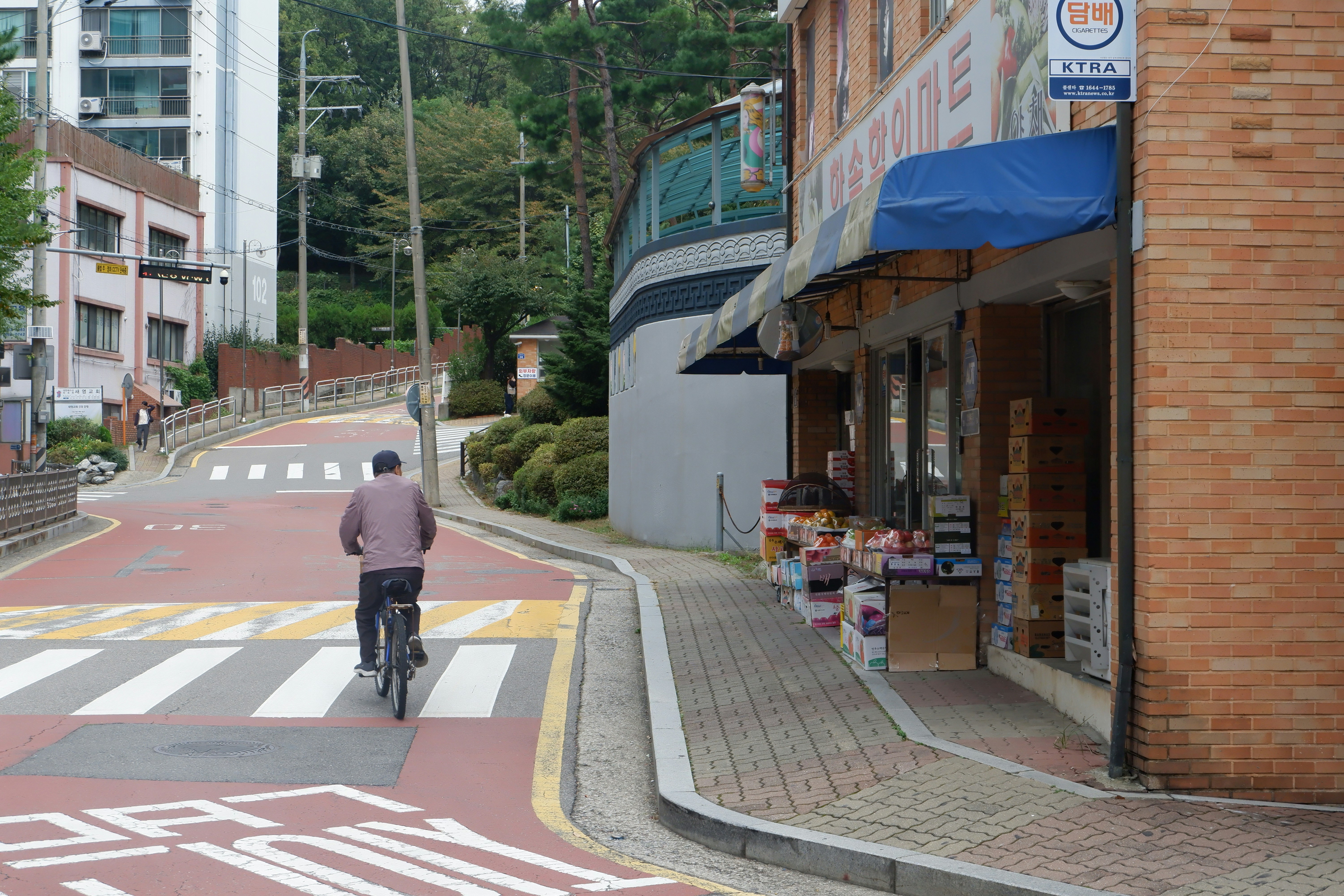 Ein Mann fährt mit dem Fahrrad eine Straße neben hohen Gebäuden entlang