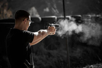 A man holding a gun with smoke coming out of it