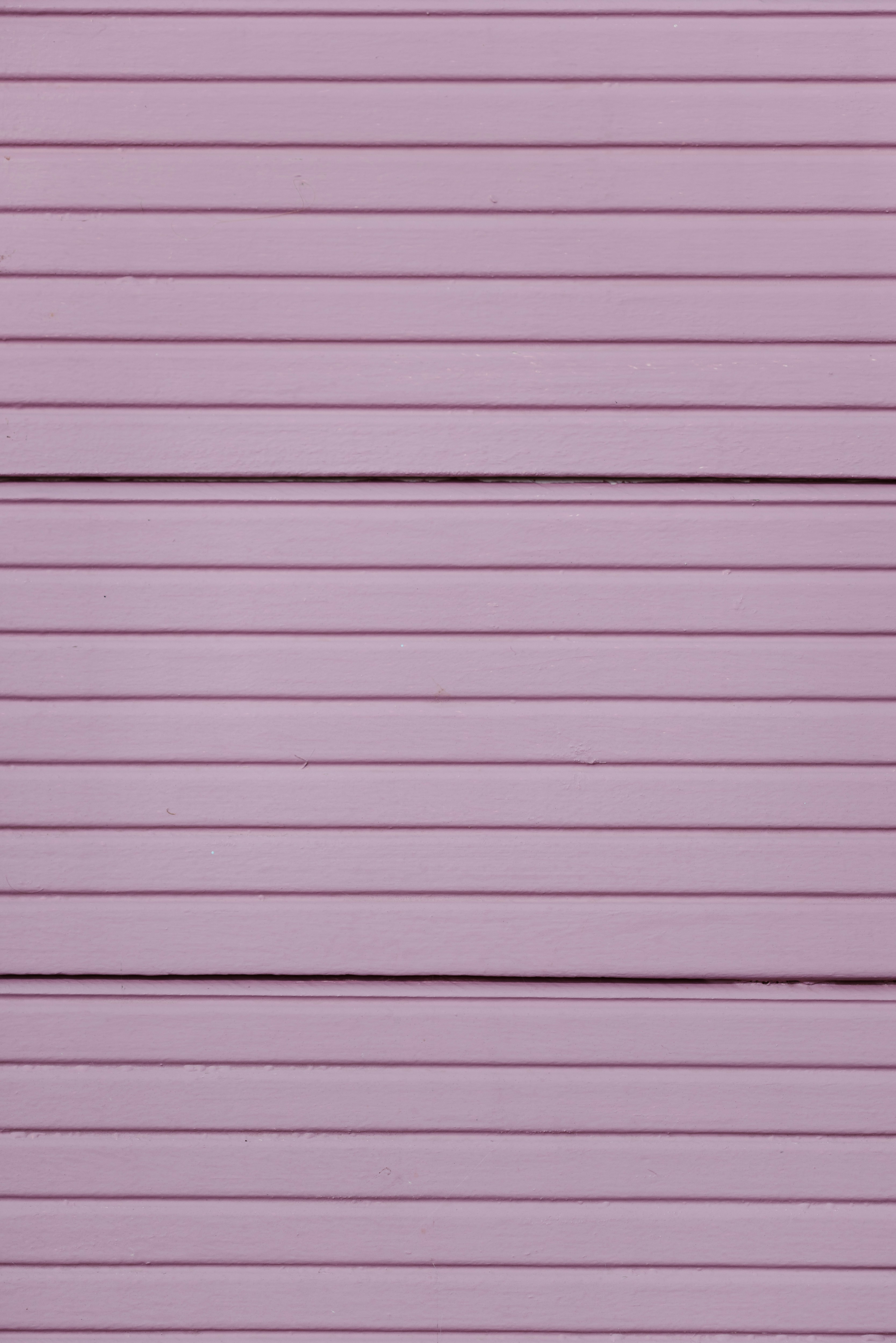 A red fire hydrant sitting in front of a purple garage door
