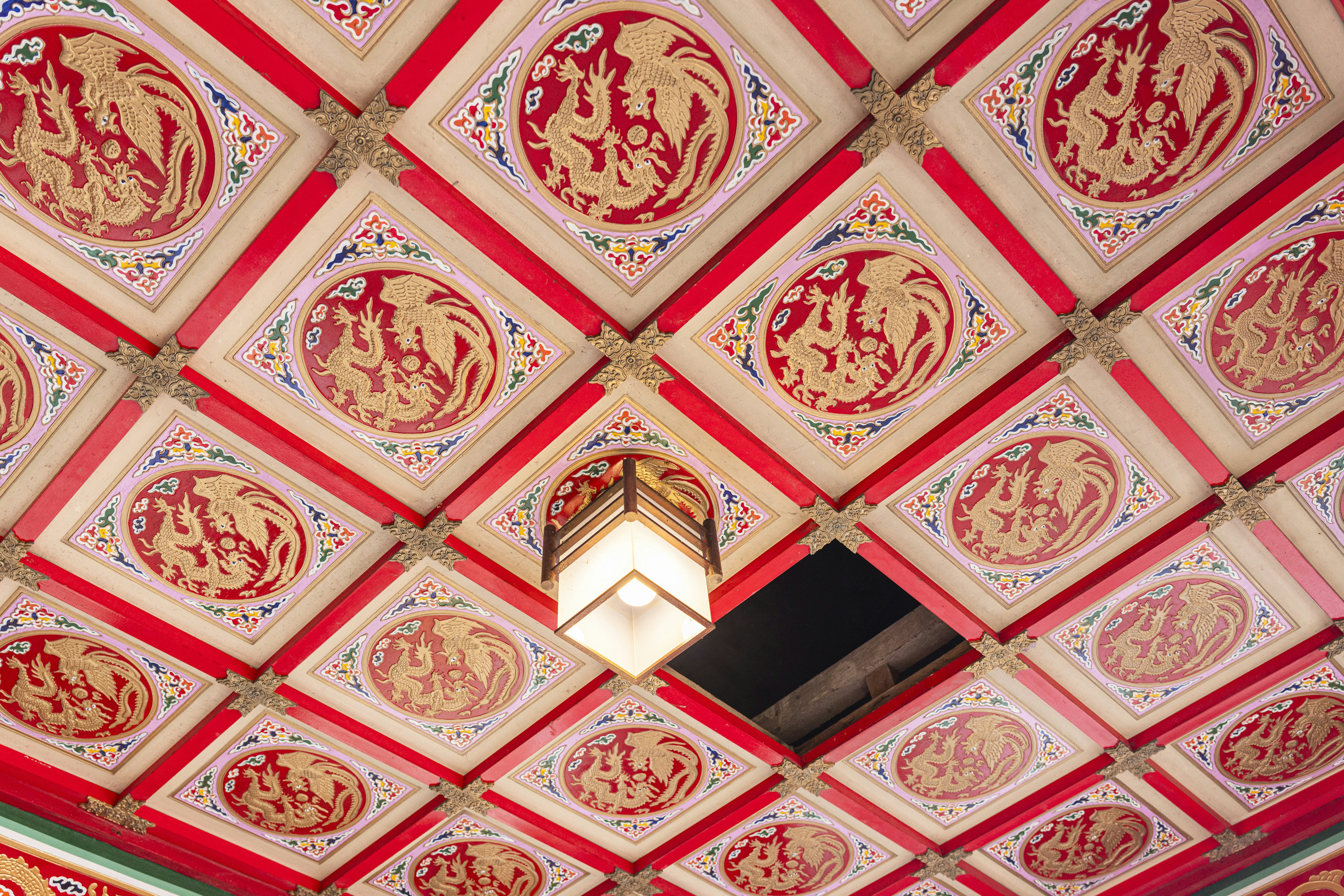 The ceiling of a building with a red and white design on it