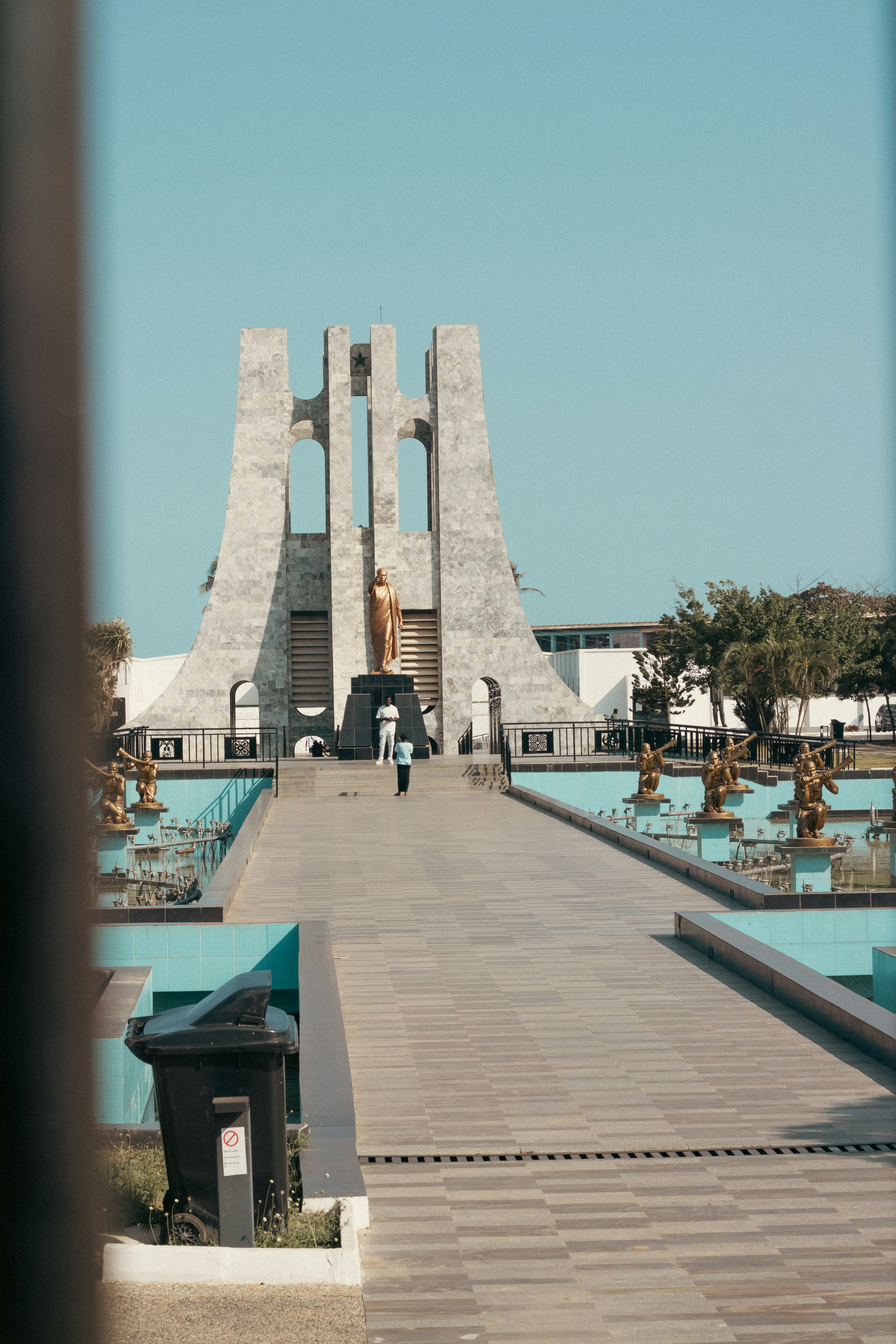A walkway leading to a monument with a clock tower in the background