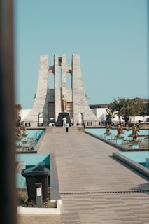 A walkway leading to a monument with a clock tower in the background