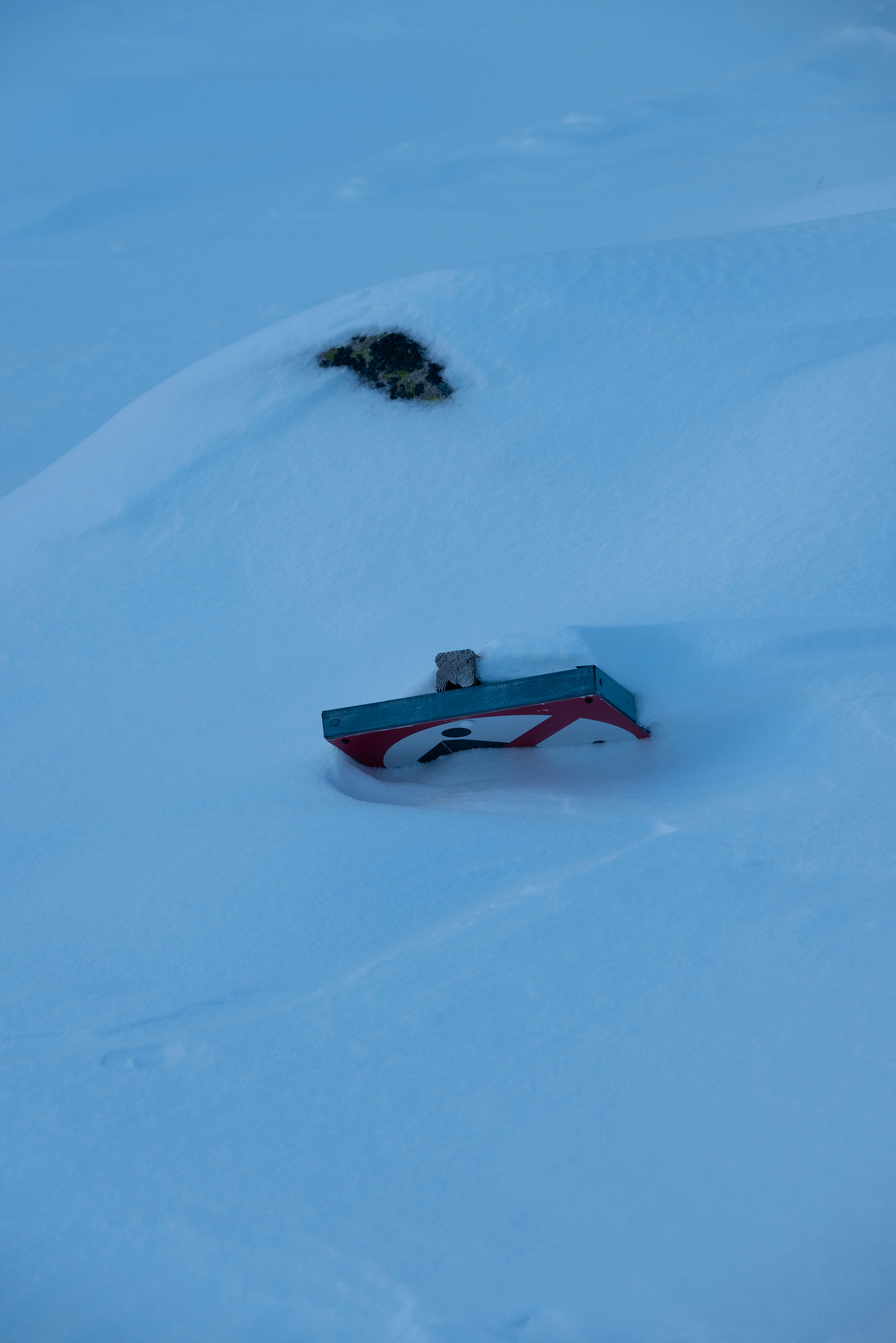 A snowboard that is laying in the snow