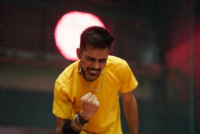 A man in a yellow shirt holding a tennis racquet