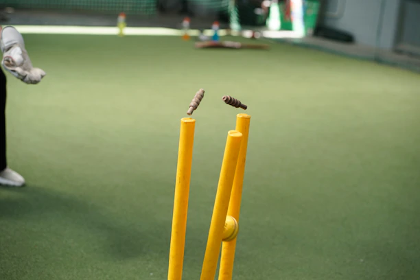 A man standing next to a yellow bat and ball