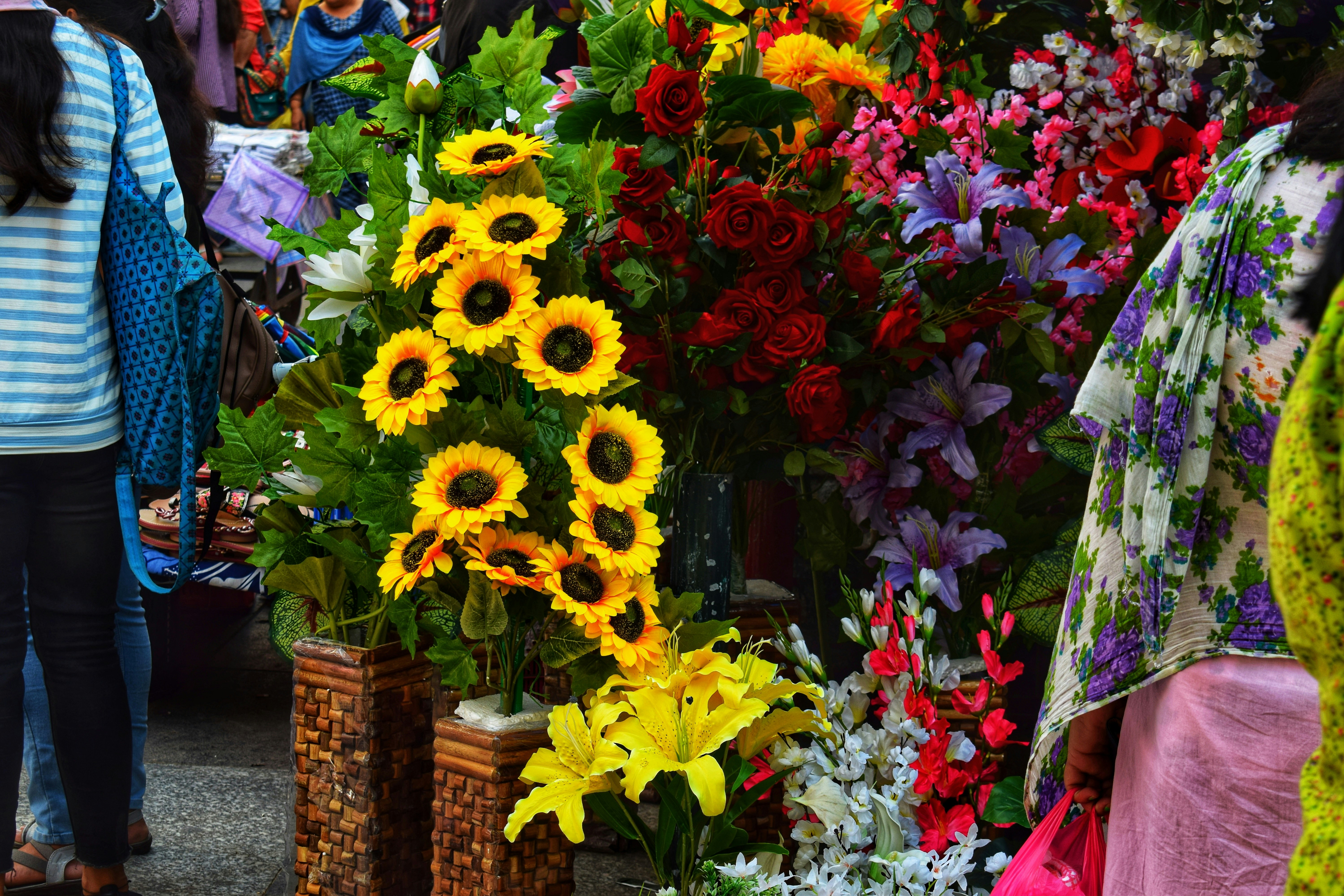 A group of people standing around a bunch of flowers photo – Free Full ...