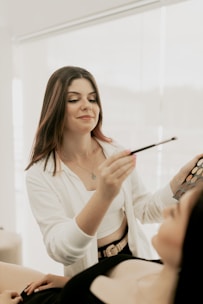 A woman getting her makeup done in a room