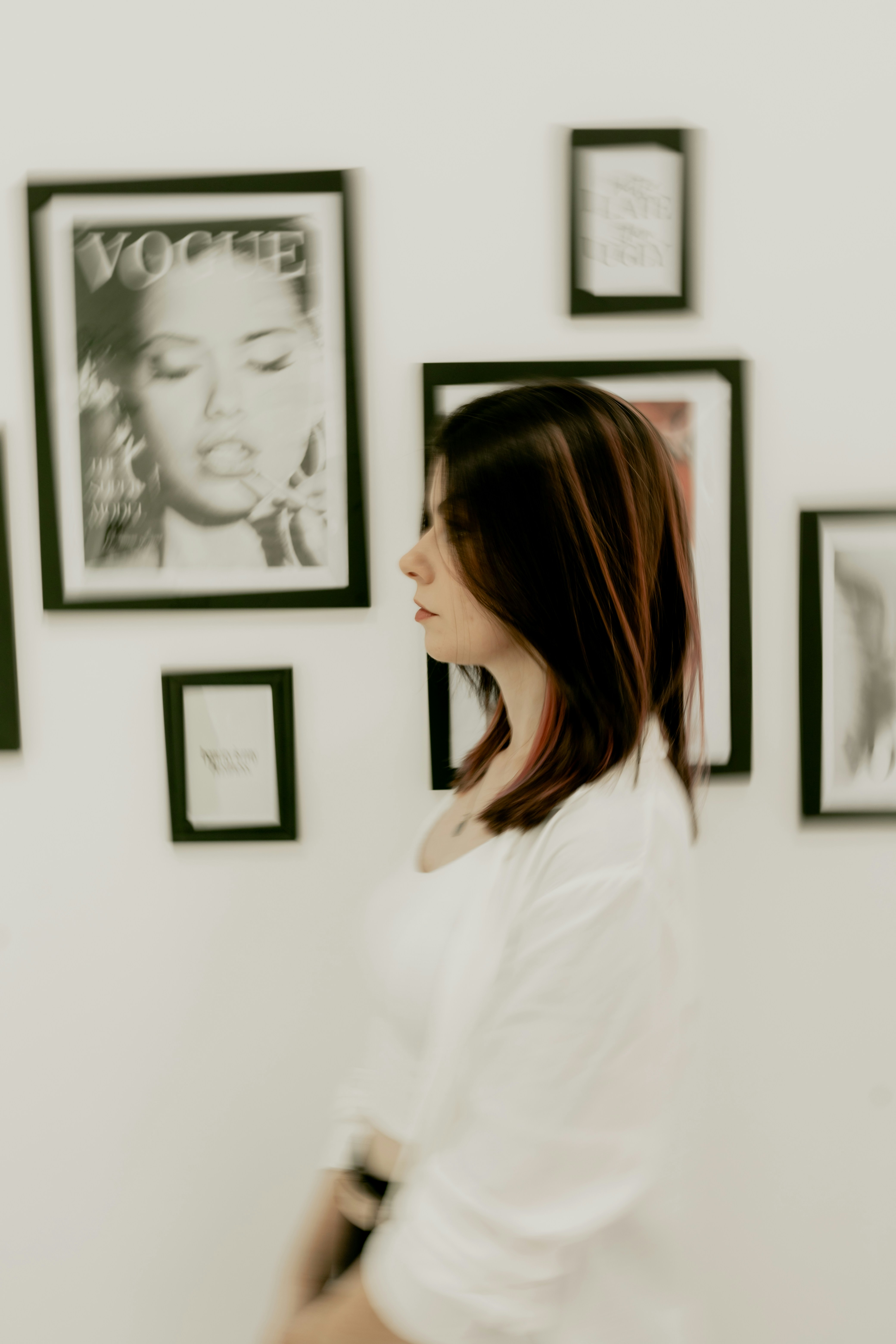 A woman standing in front of a wall with pictures on it photo – Free ...