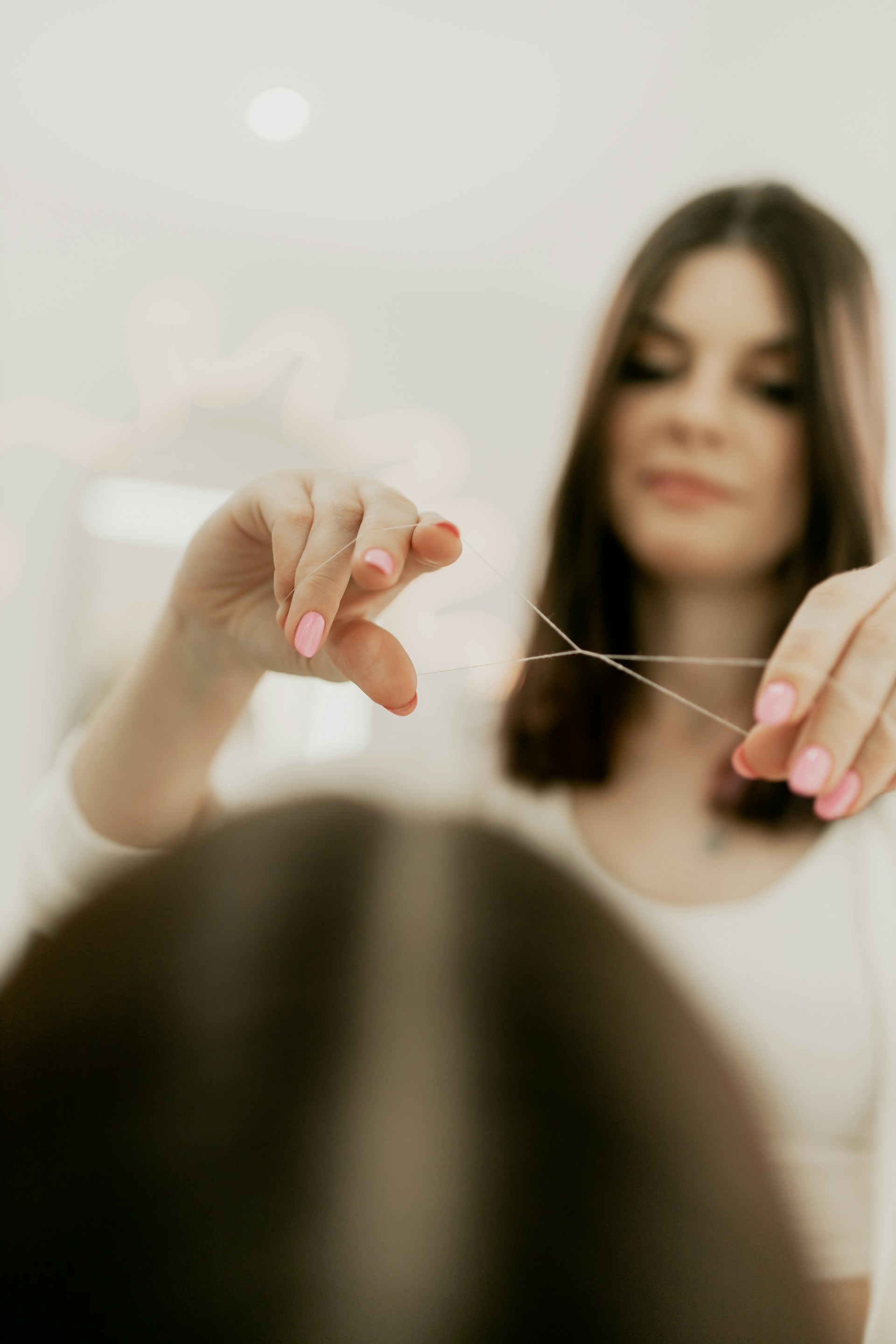 A woman in a white shirt is holding a string