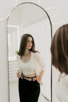 A woman standing in front of a mirror