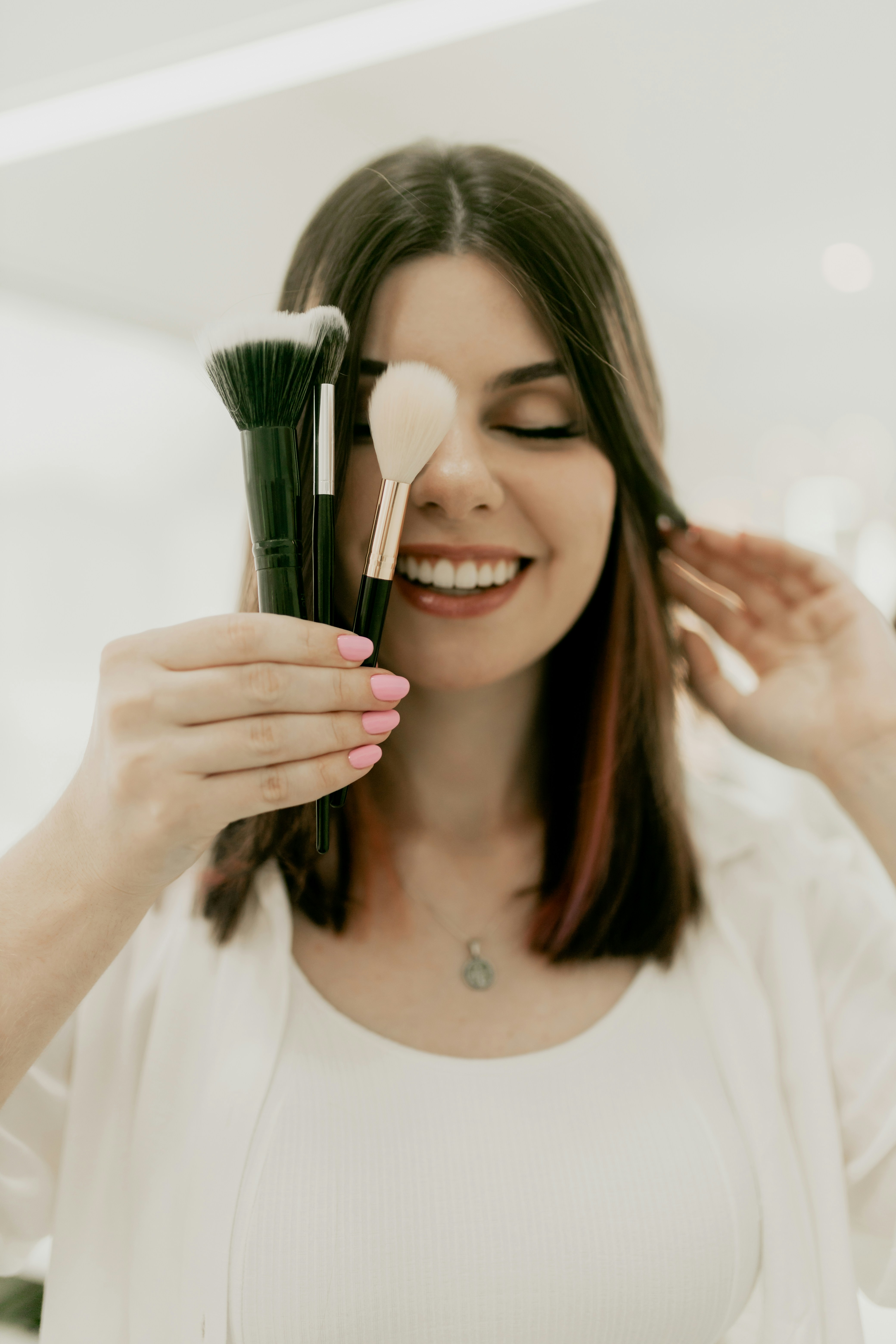 Woman holding a brush and mirror in a bright minimal setting