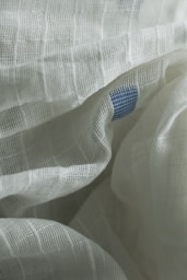 A close up of a white sheet with a blue dot on it