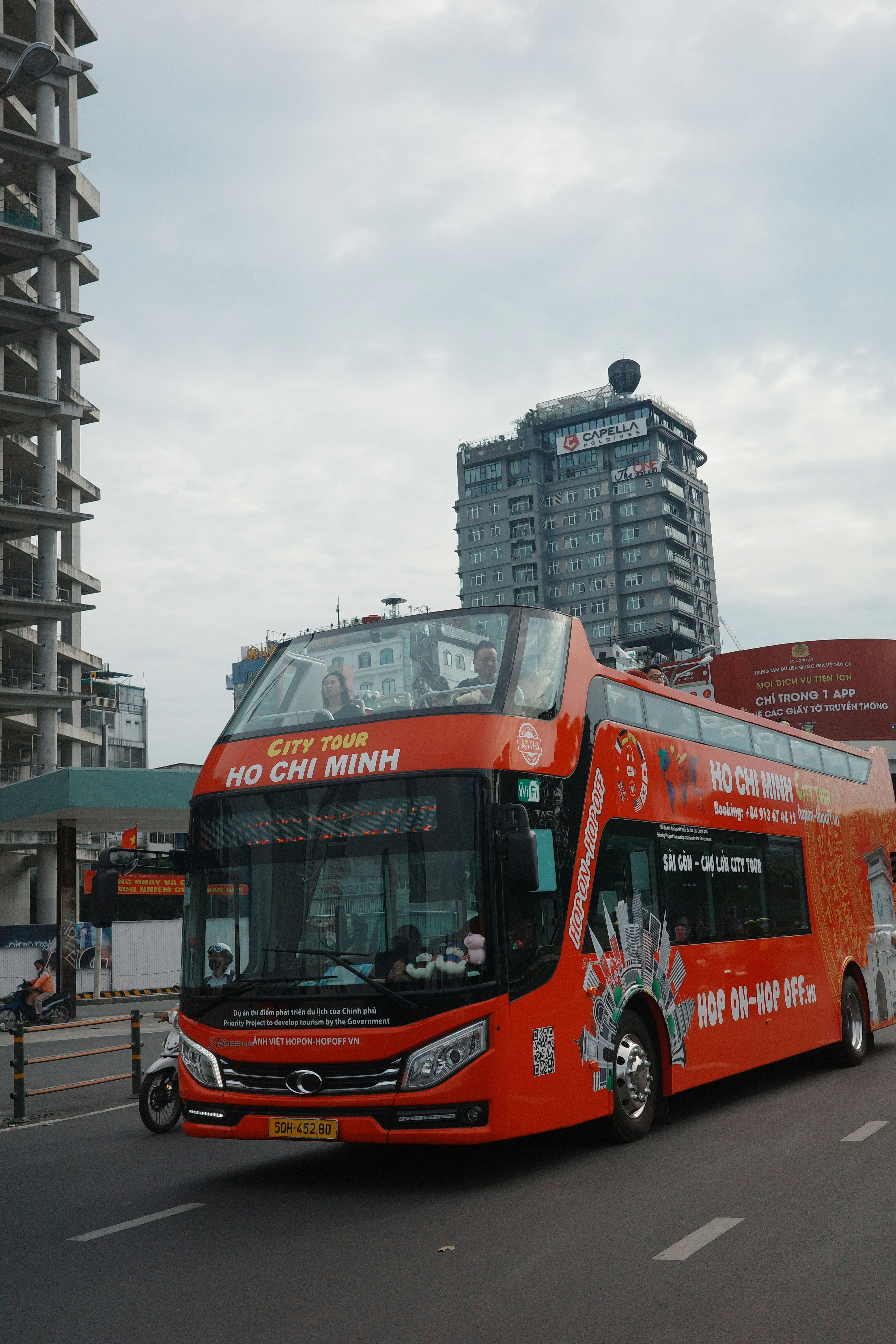 A red double decker bus driving down a street