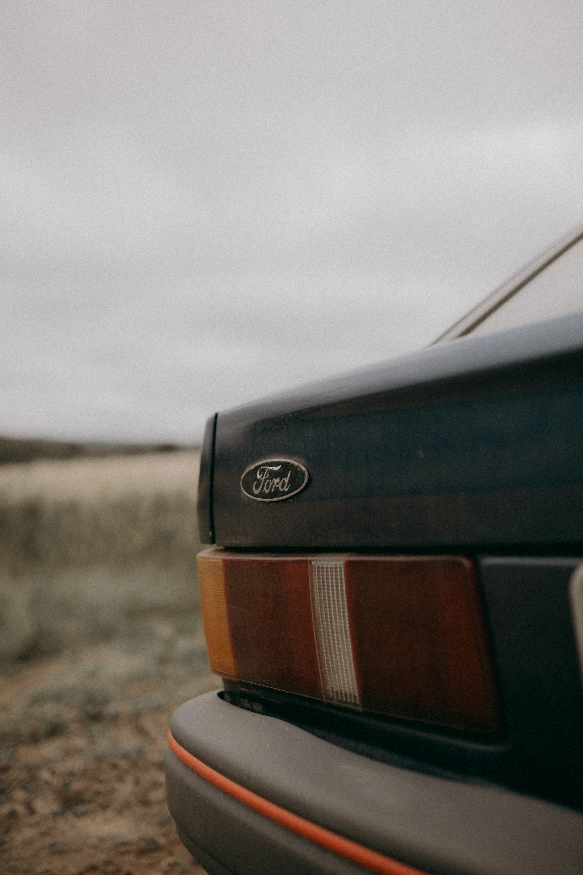 A close up of a car parked on a dirt road