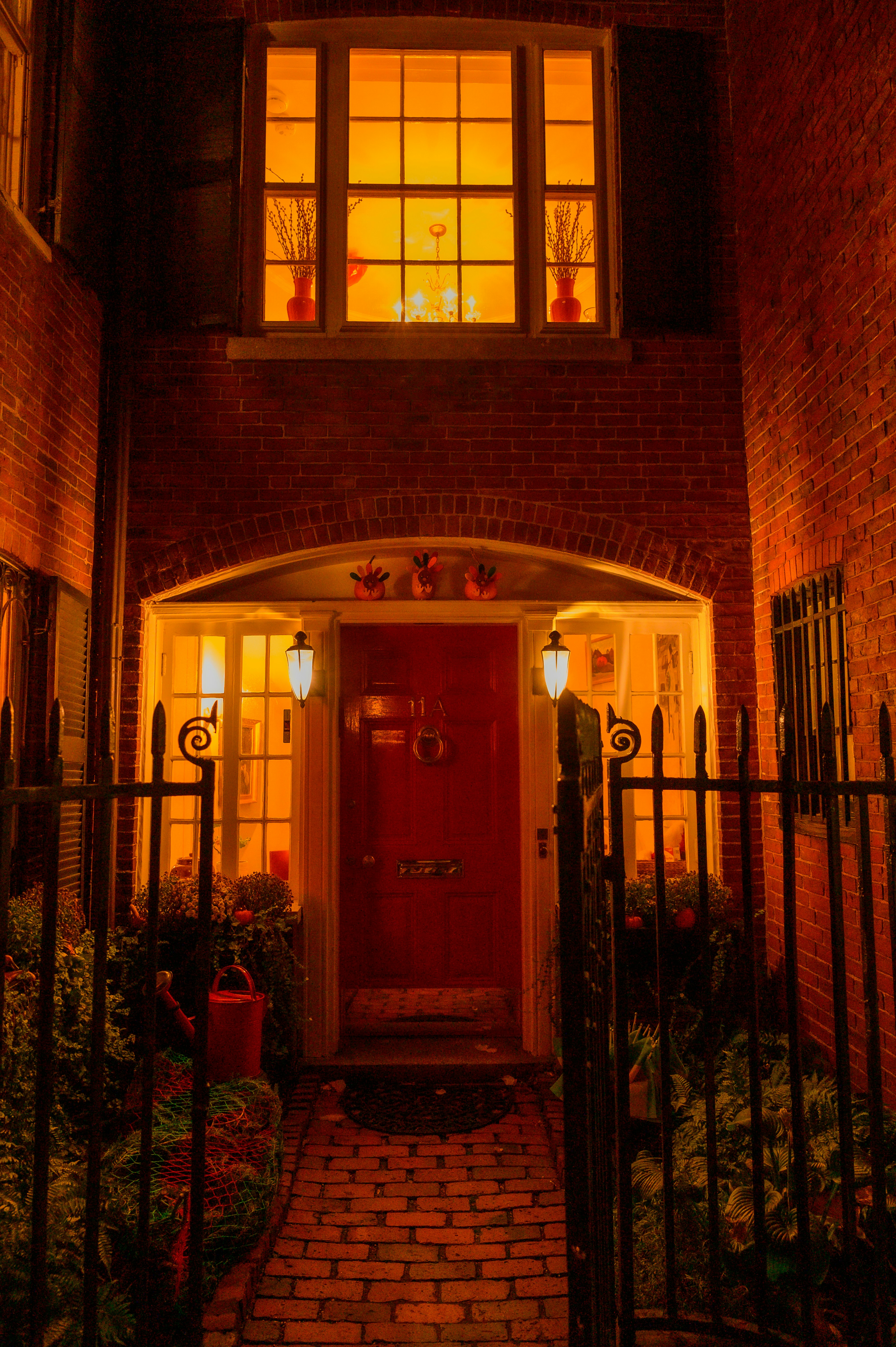 A red door is lit up at night