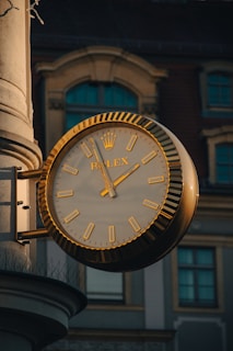 A clock on a pole in front of a building