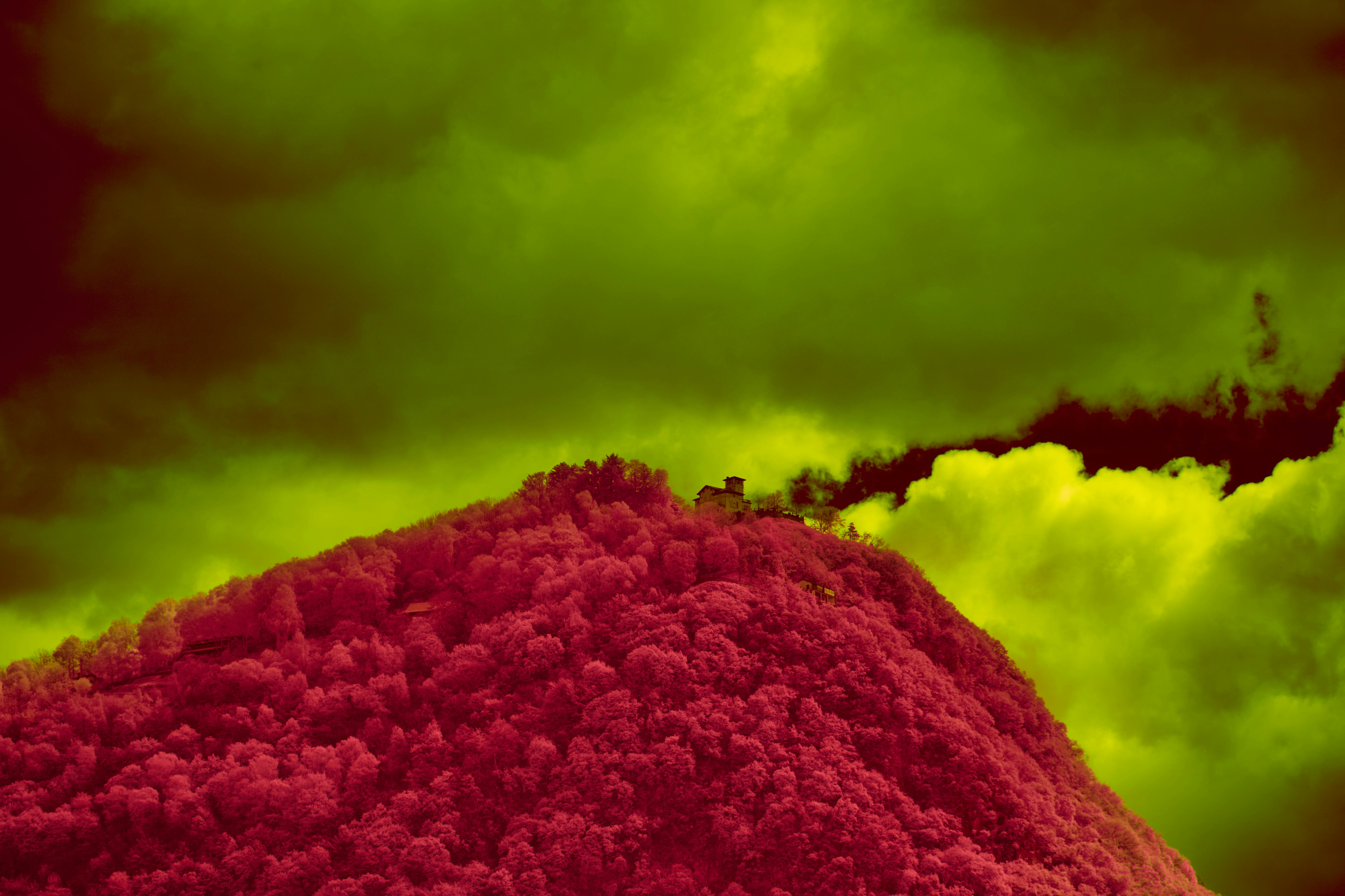 A large mound of red dirt under a cloudy sky, 
