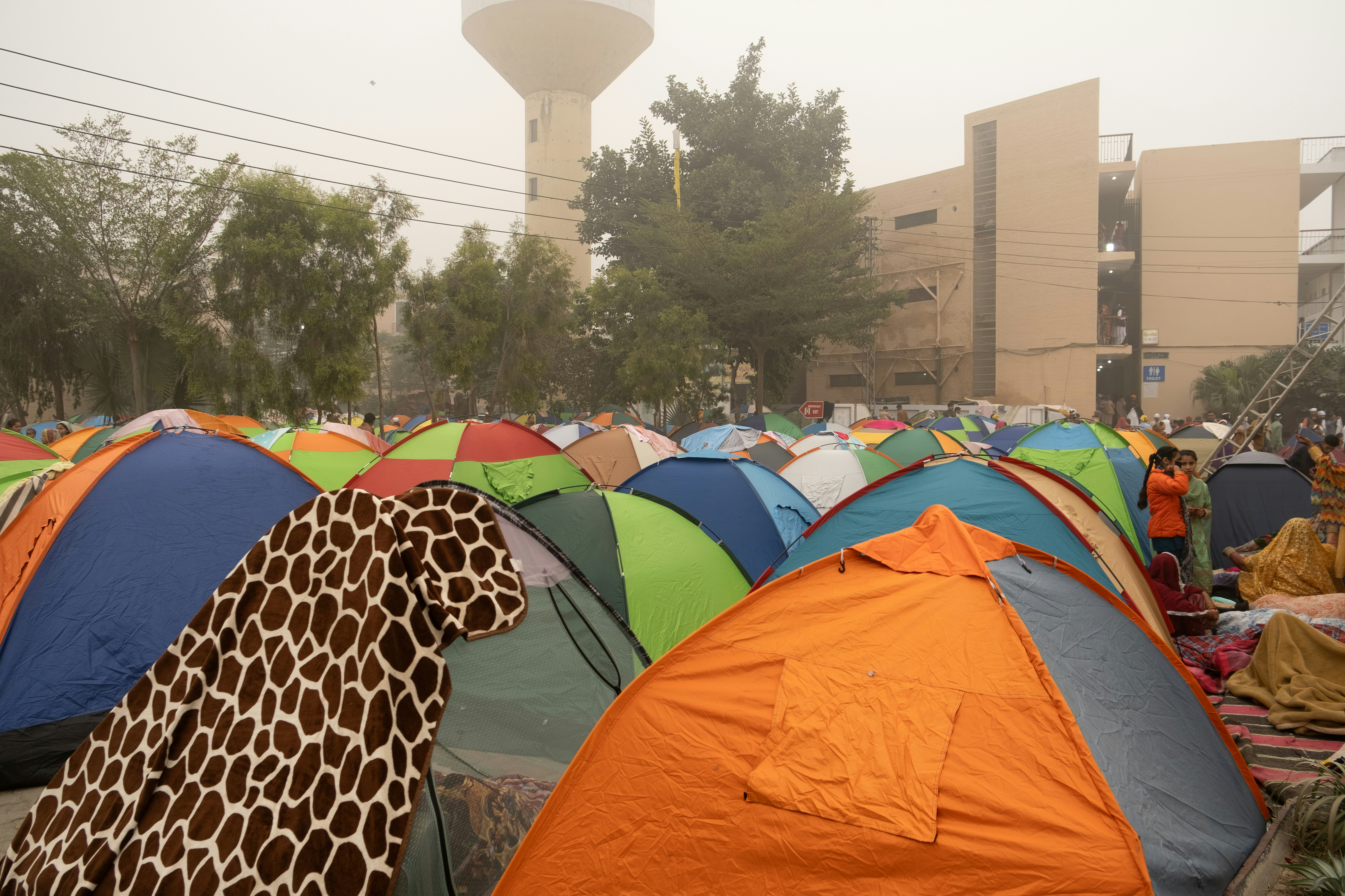 A large group of tents with a water tower in the background