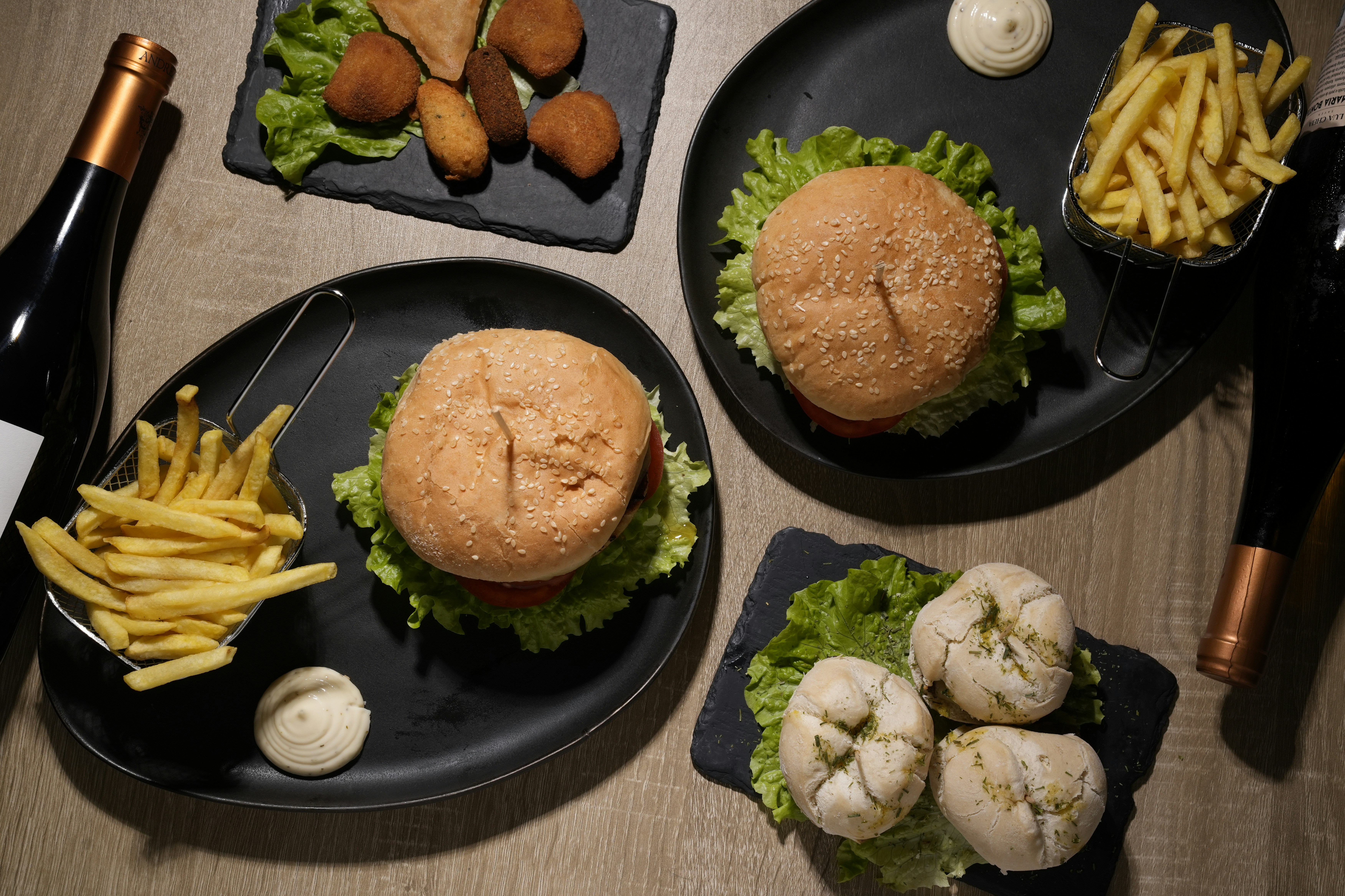 A table topped with plates of food and a bottle of wine