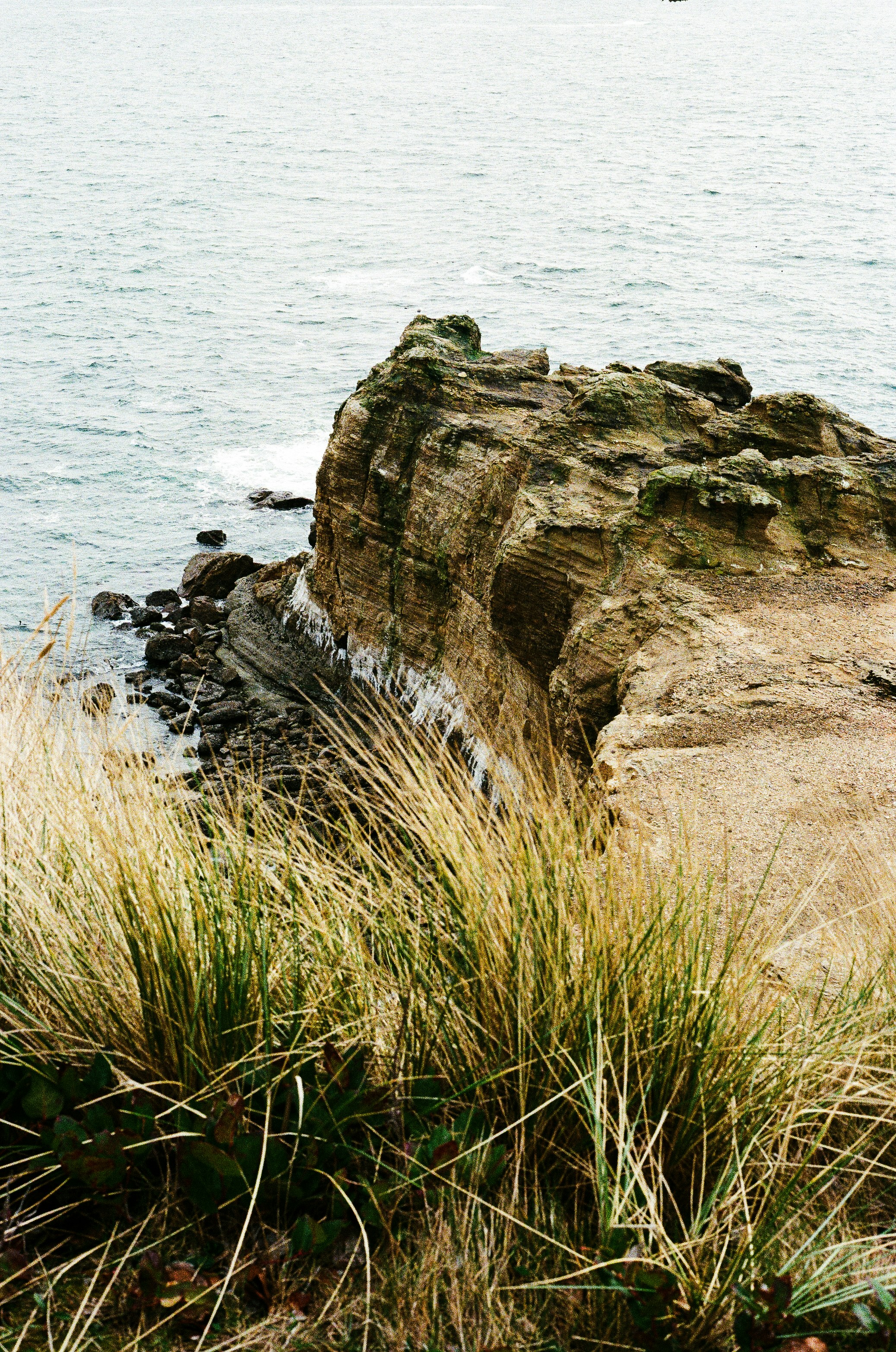 A man standing on a cliff overlooking the ocean