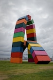 A large multicolored sculpture in the middle of a field