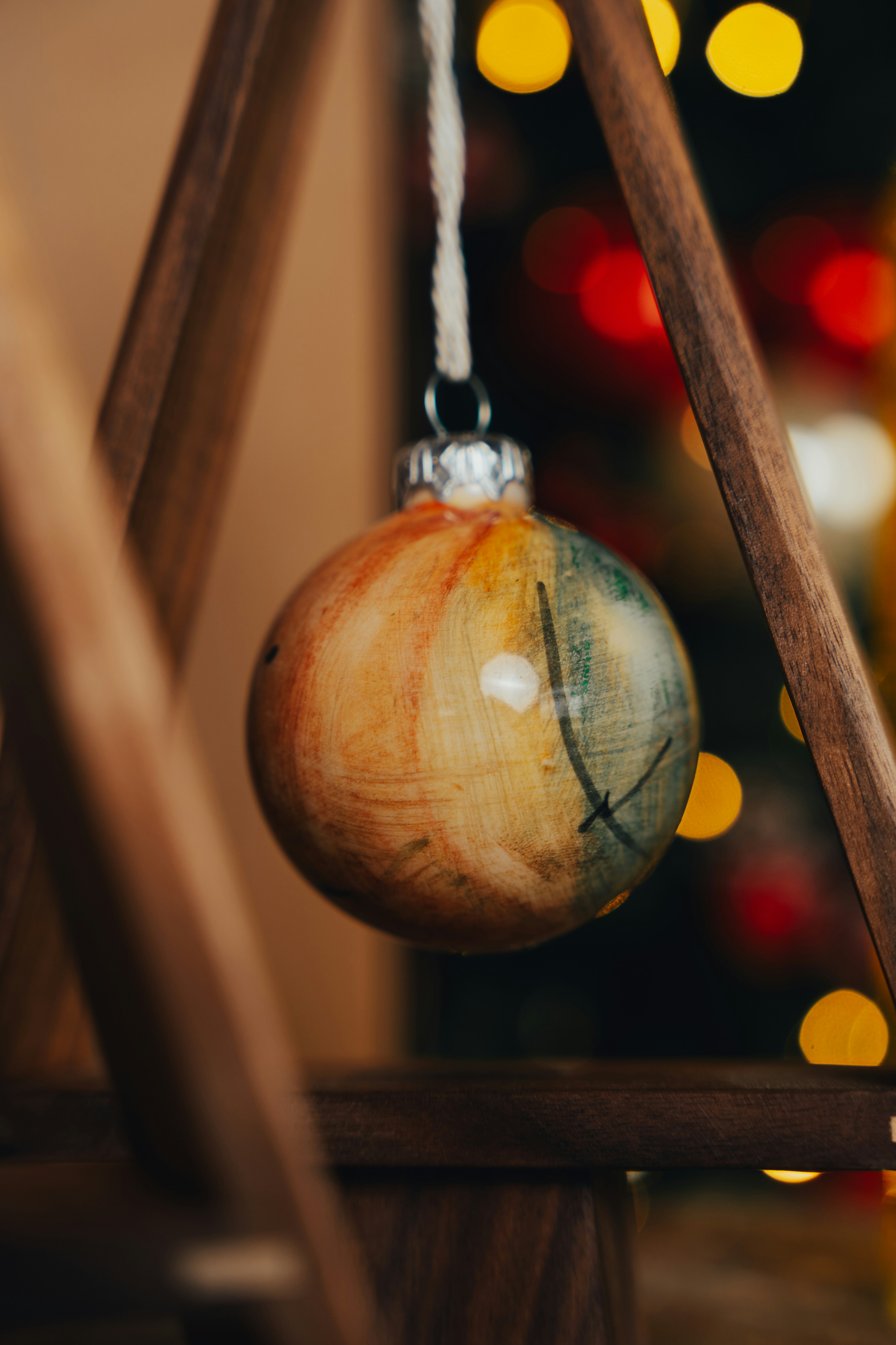 A wooden chair with a christmas ornament hanging from it