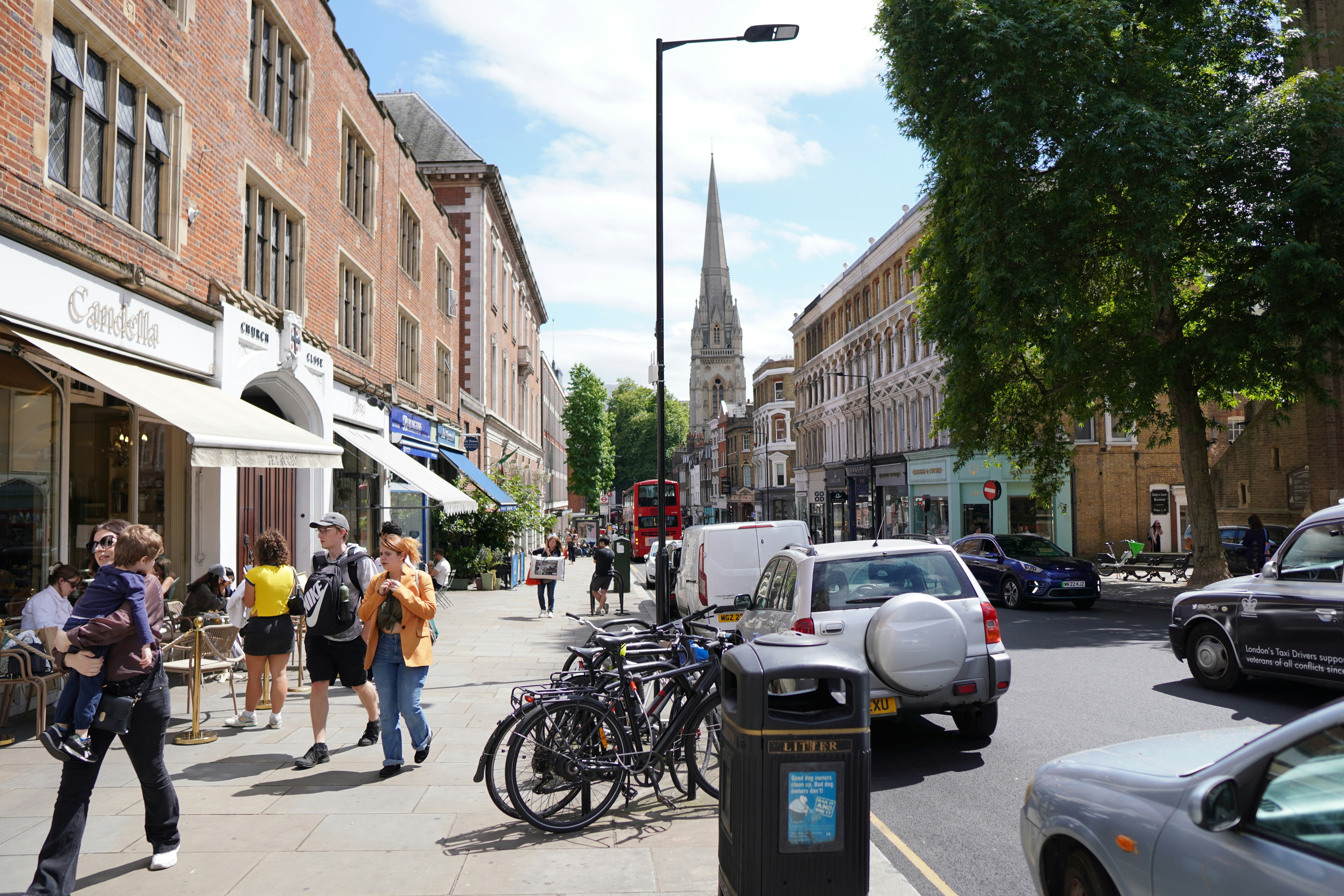 Eine Gruppe von Menschen geht eine Straße neben hohen Gebäuden entlang