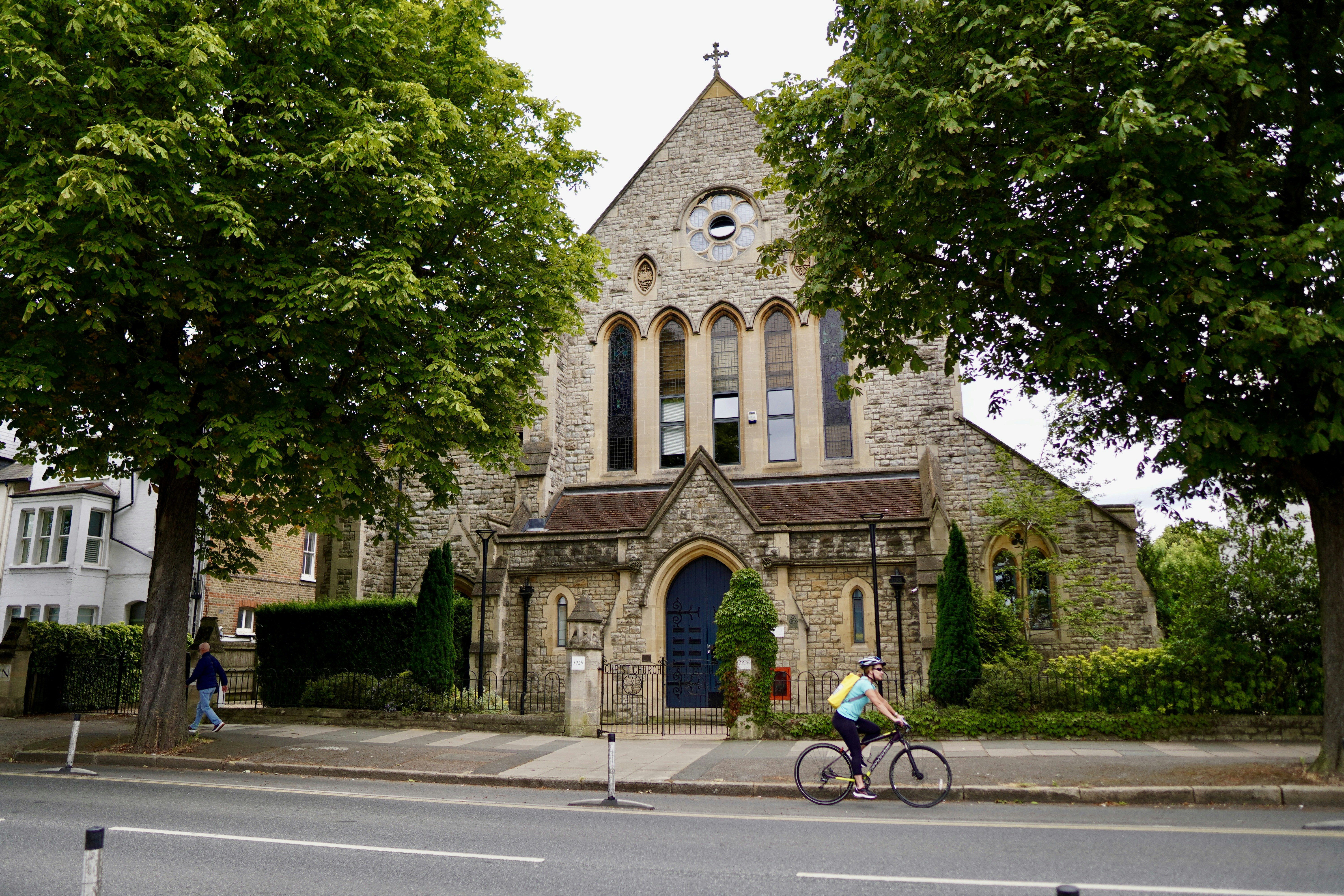 Eine Person, die mit dem Fahrrad vor einer Kirche fährt