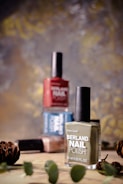 A bottle of nail polish next to some pine cones