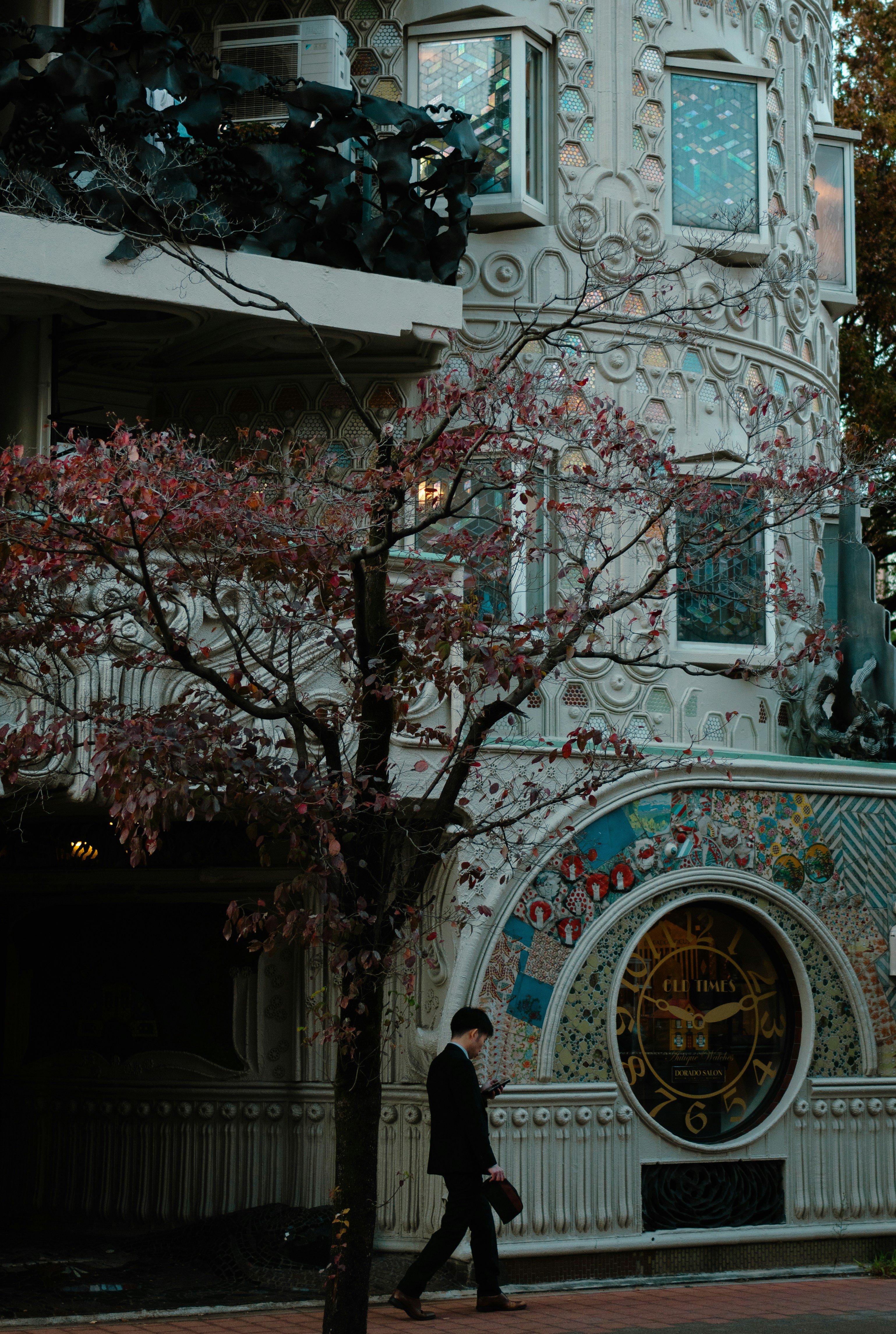 A man walking down a street past a tall building
