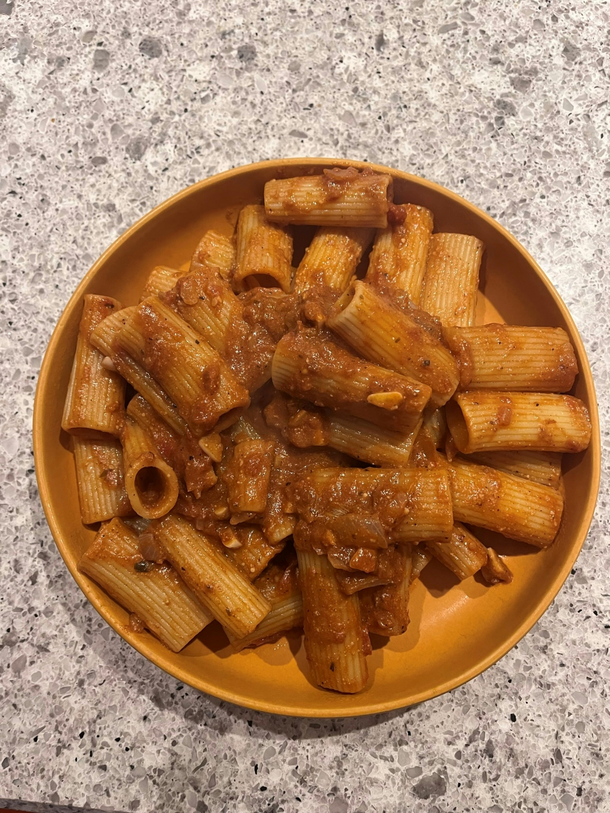 Rigatoni pasta with rich red tomato amatriciana sauce, crispy guanciale, and grated pecorino