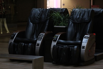 A couple of black chairs sitting on top of a hard wood floor