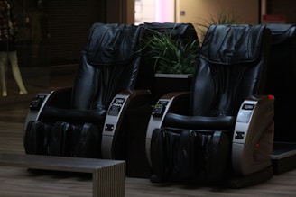 A couple of black chairs sitting on top of a hard wood floor