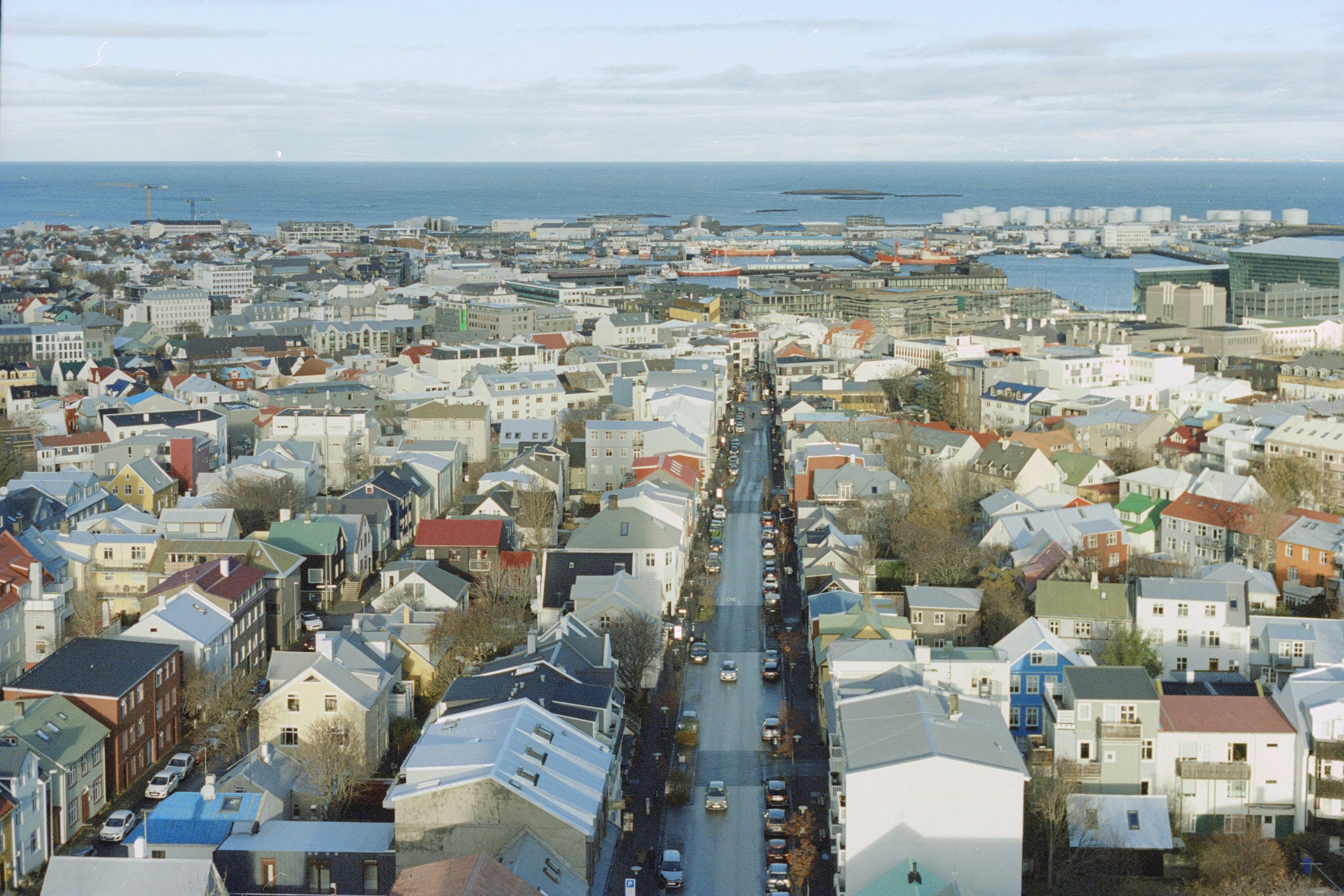 An aerial view of a city with a body of water in the background