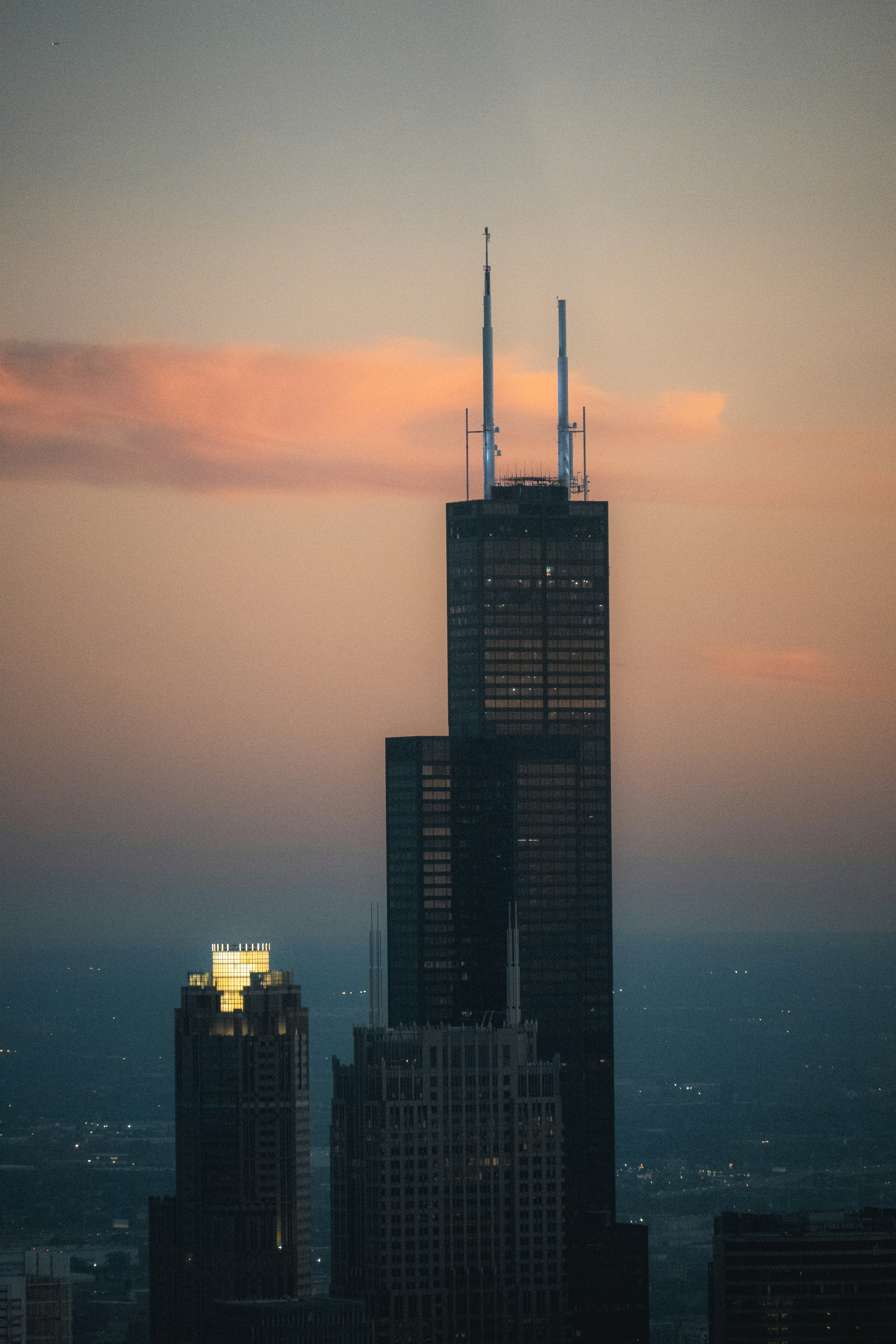 Um edifício muito alto com uma linha do horizonte ao fundo