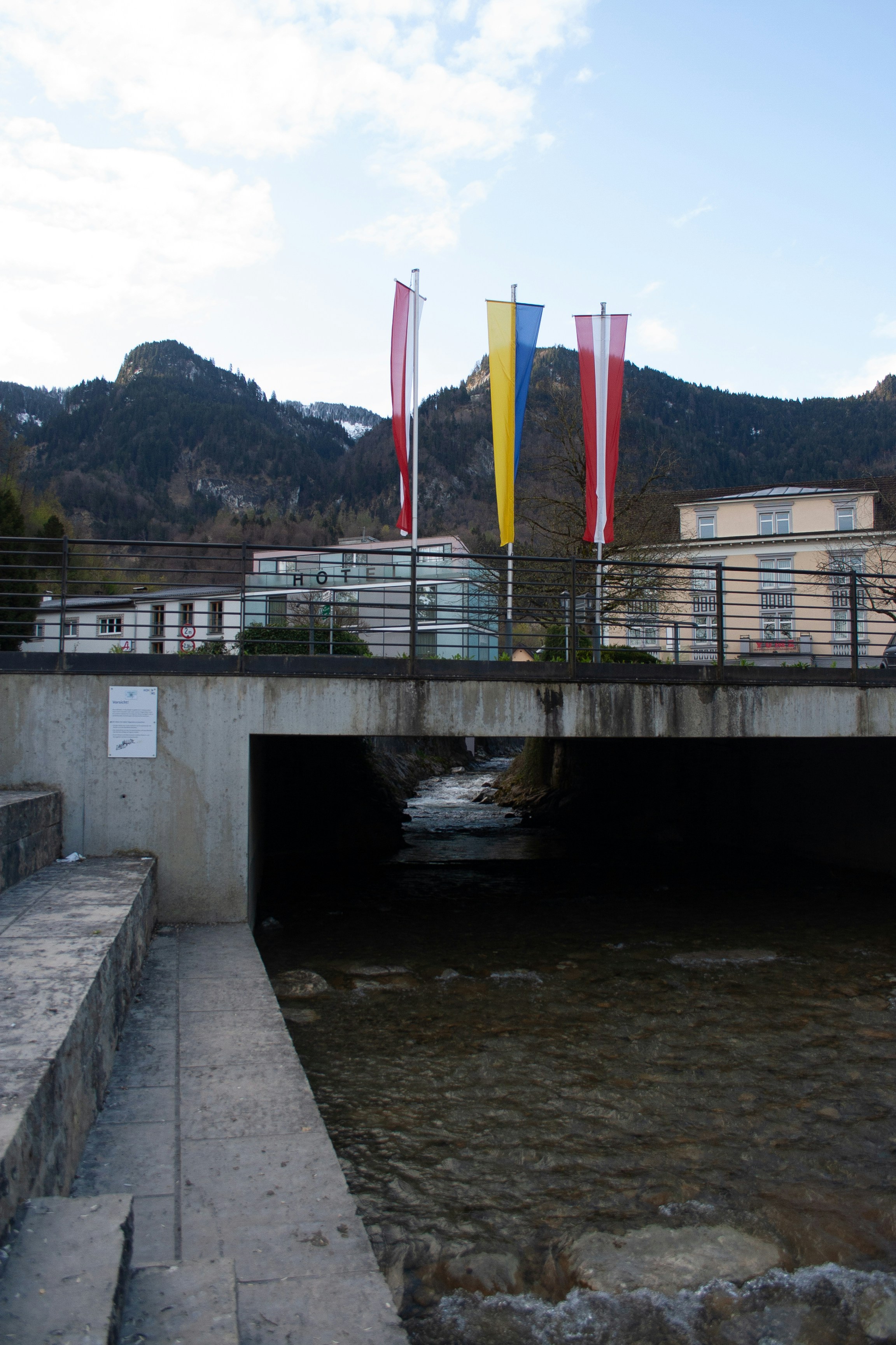 A bridge over a river with a bunch of flags on it