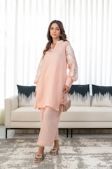 A woman standing in front of a couch in a living room