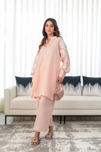 A woman standing in front of a couch in a living room