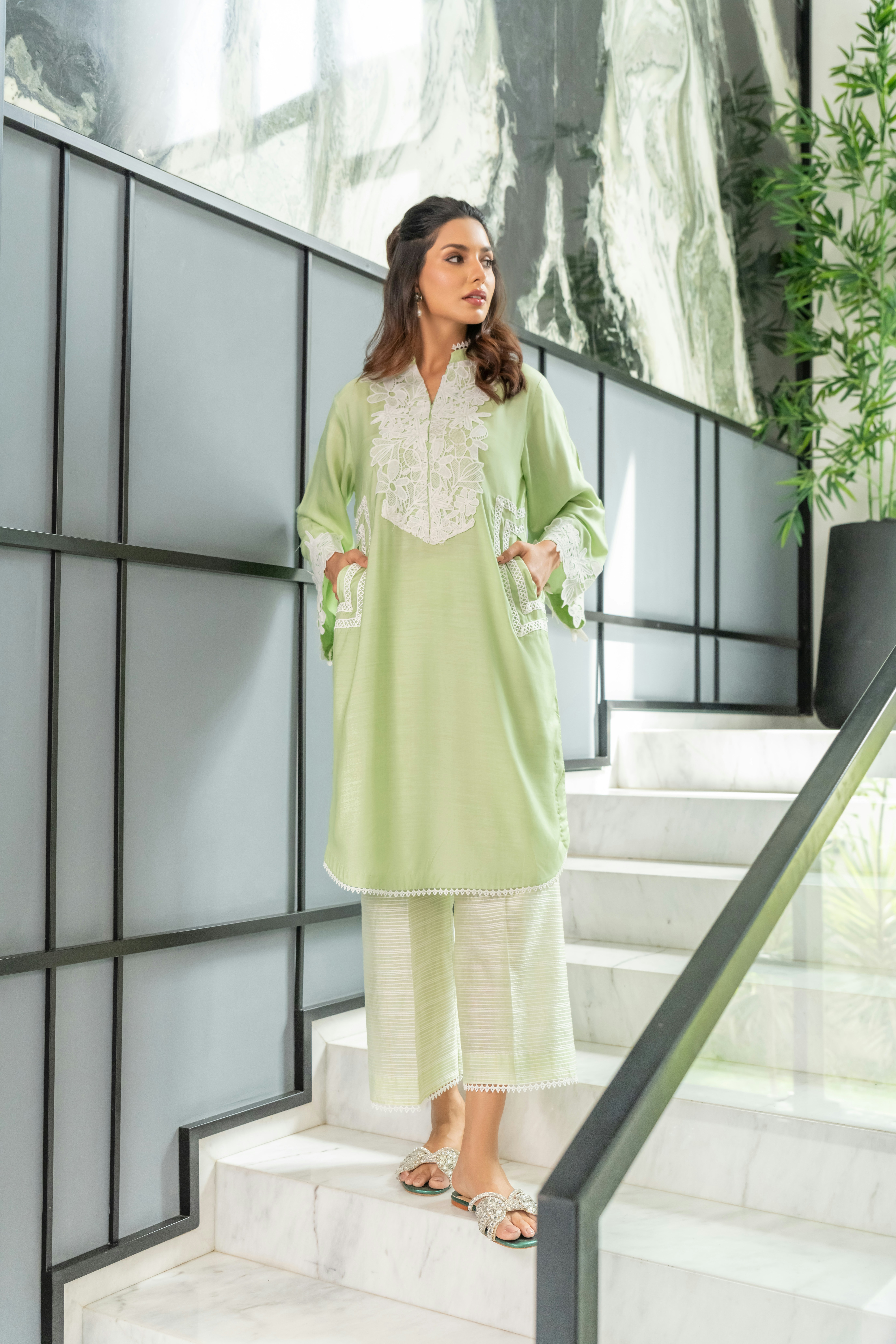 A woman in a green outfit standing on some stairs