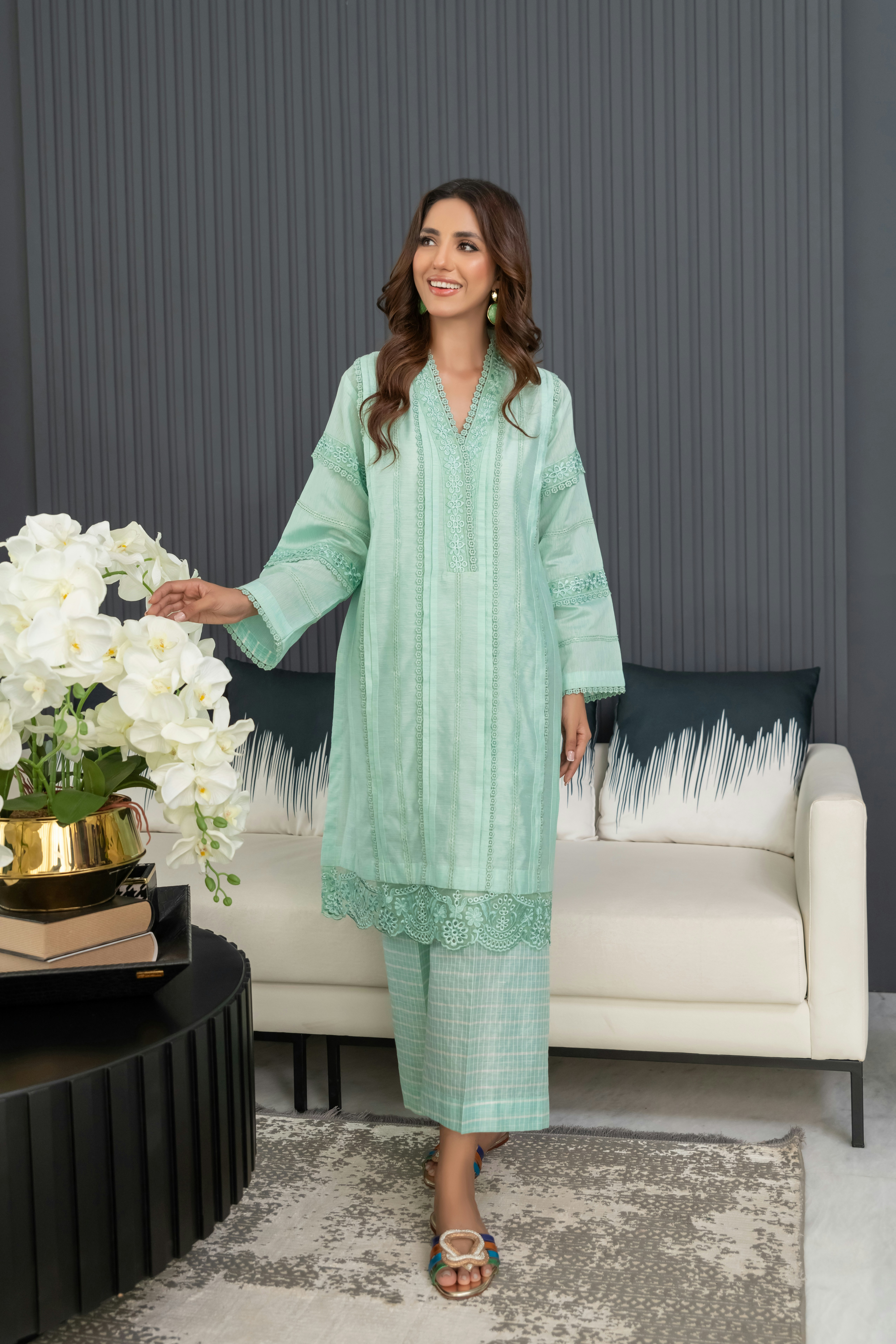 A woman standing in a living room next to a couch