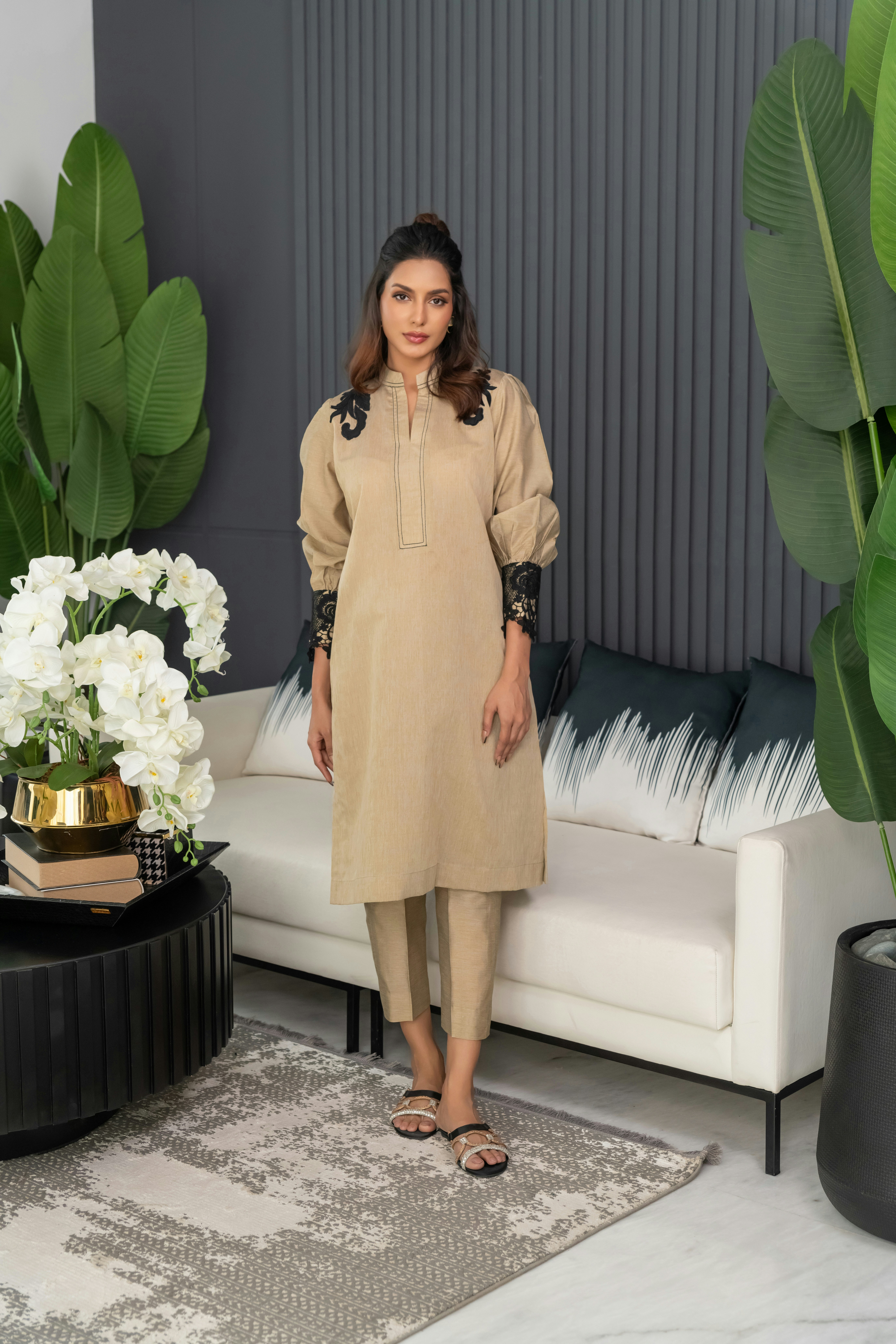 A woman standing in a living room next to a couch
