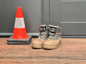 A pair of shoes sitting next to a traffic cone