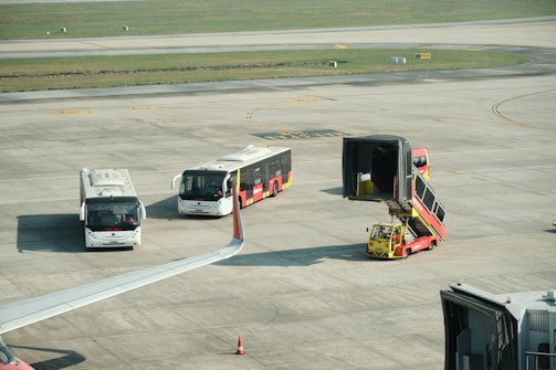 A group of buses sitting on top of an airport tarmac