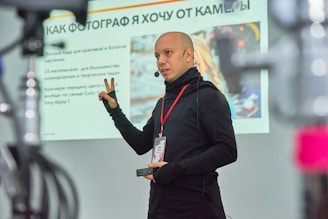 A man standing in front of a projector screen