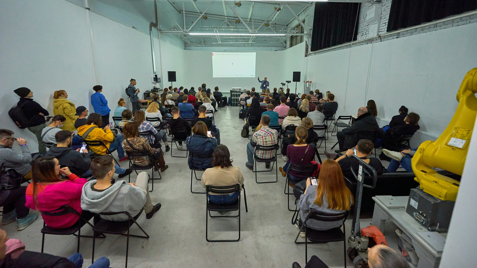 A large group of people sitting in chairs in a room