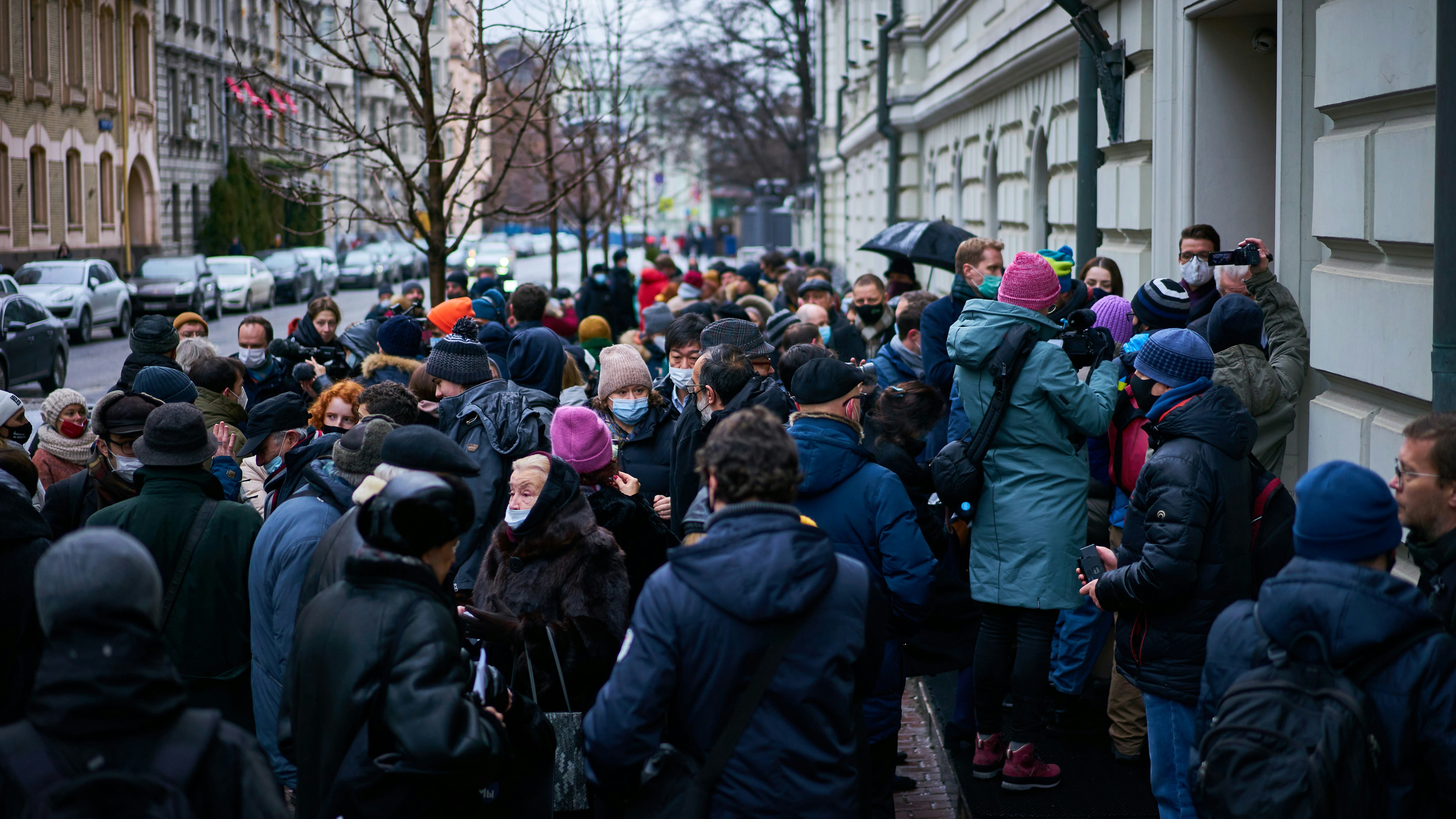 A large group of people standing on the side of a street