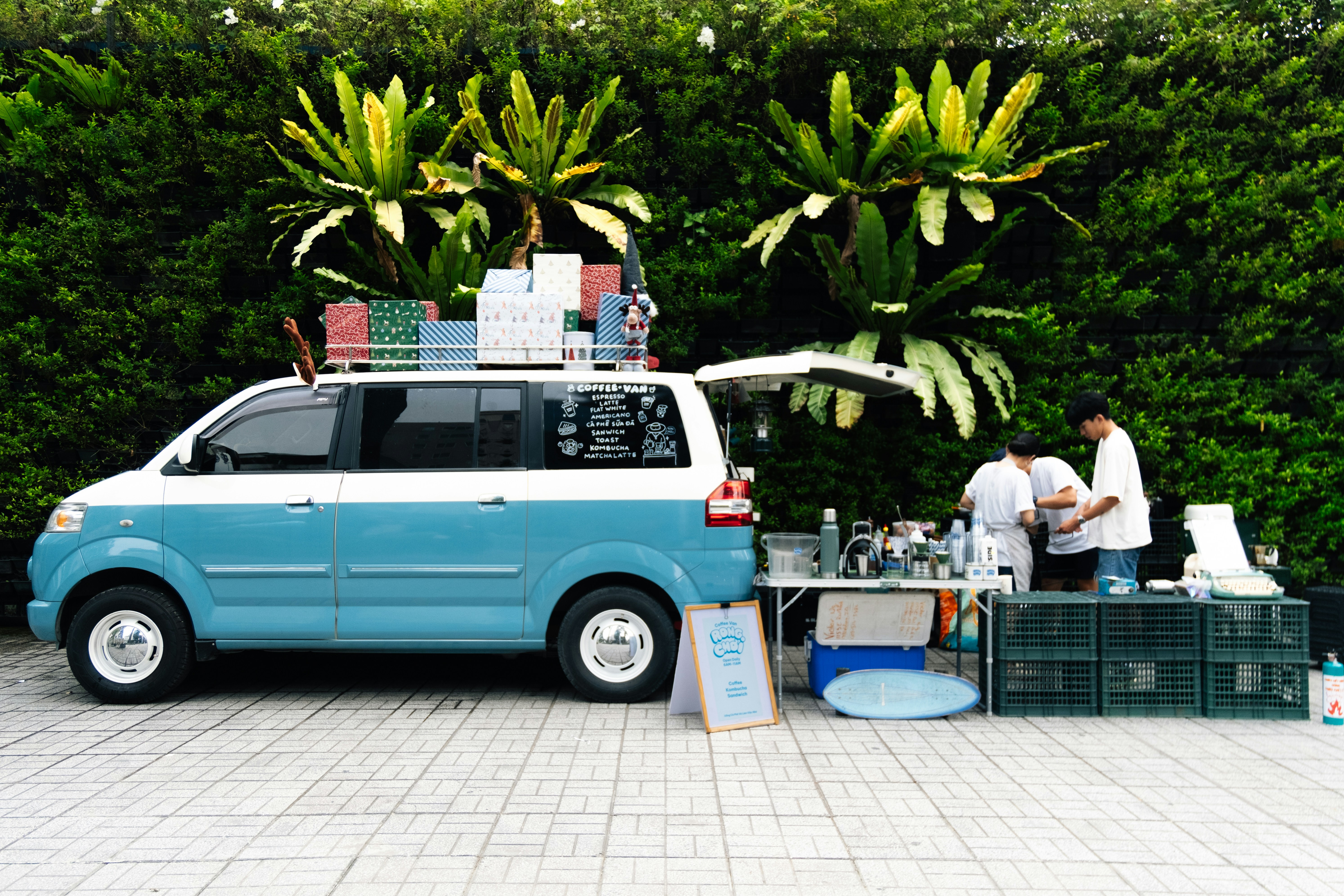 Une camionnette bleue garée à côté d’une forêt verdoyante