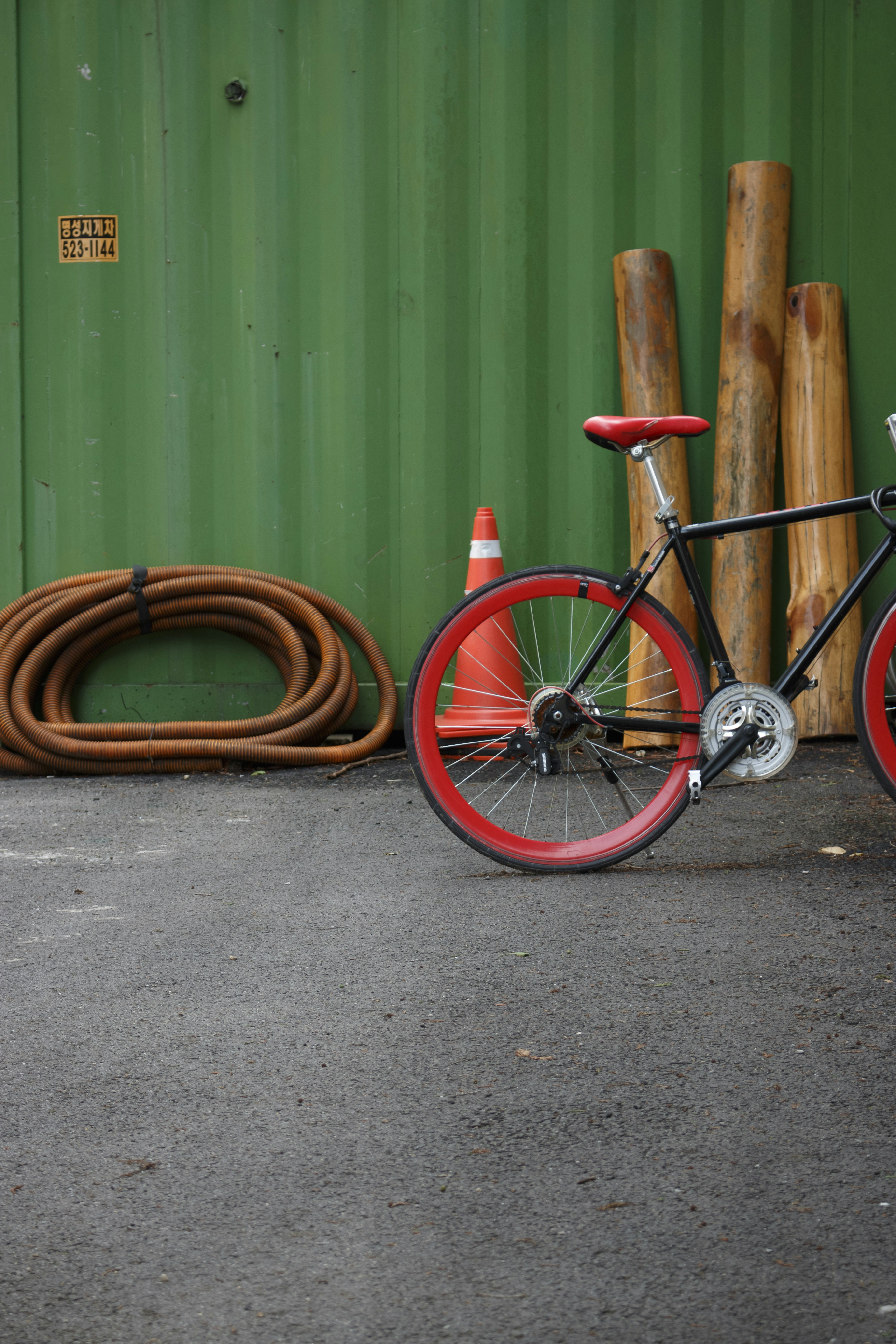A bicycle parked next to a green building