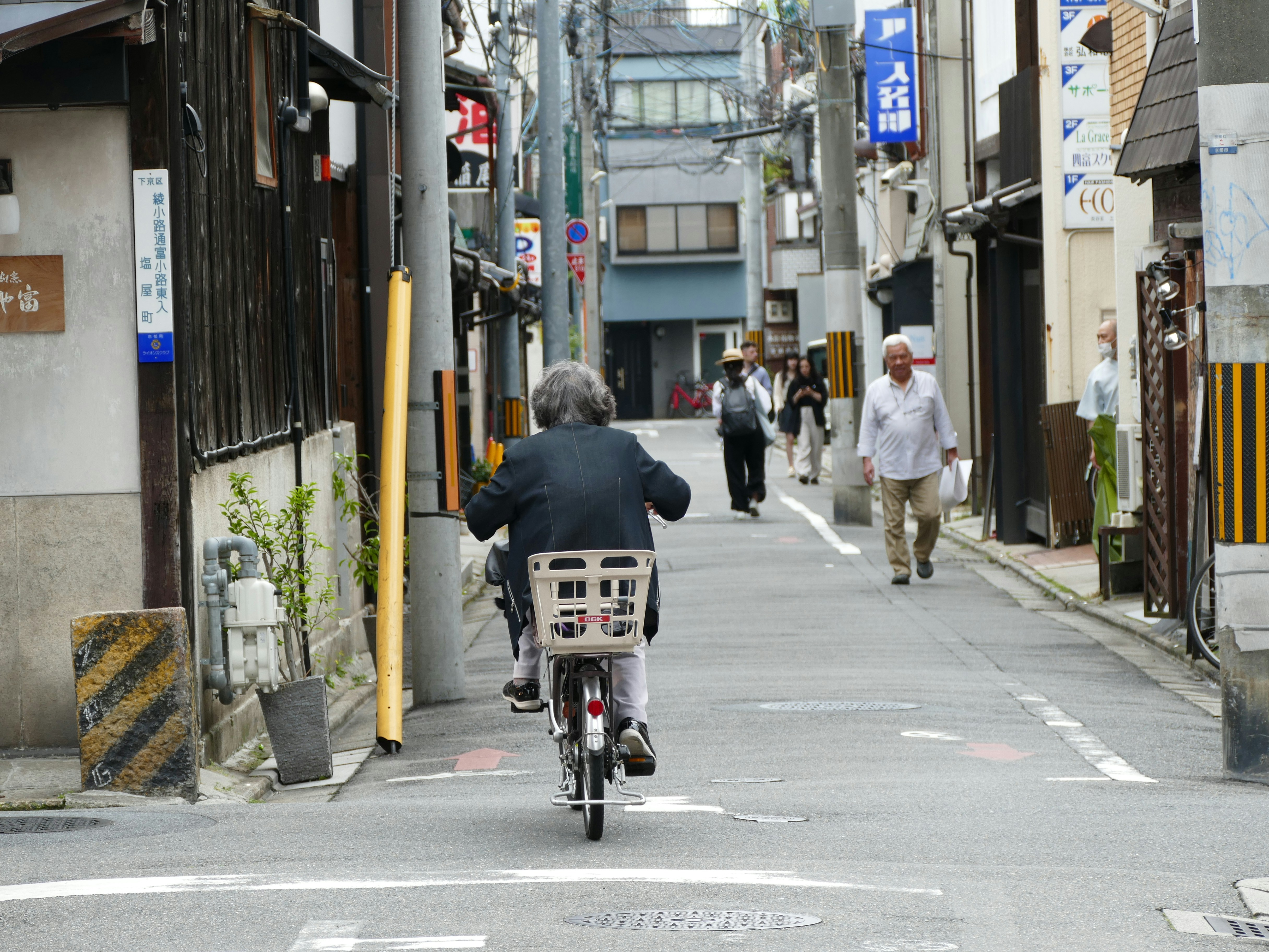 Un hombre andando en bicicleta por una calle junto a edificios altos