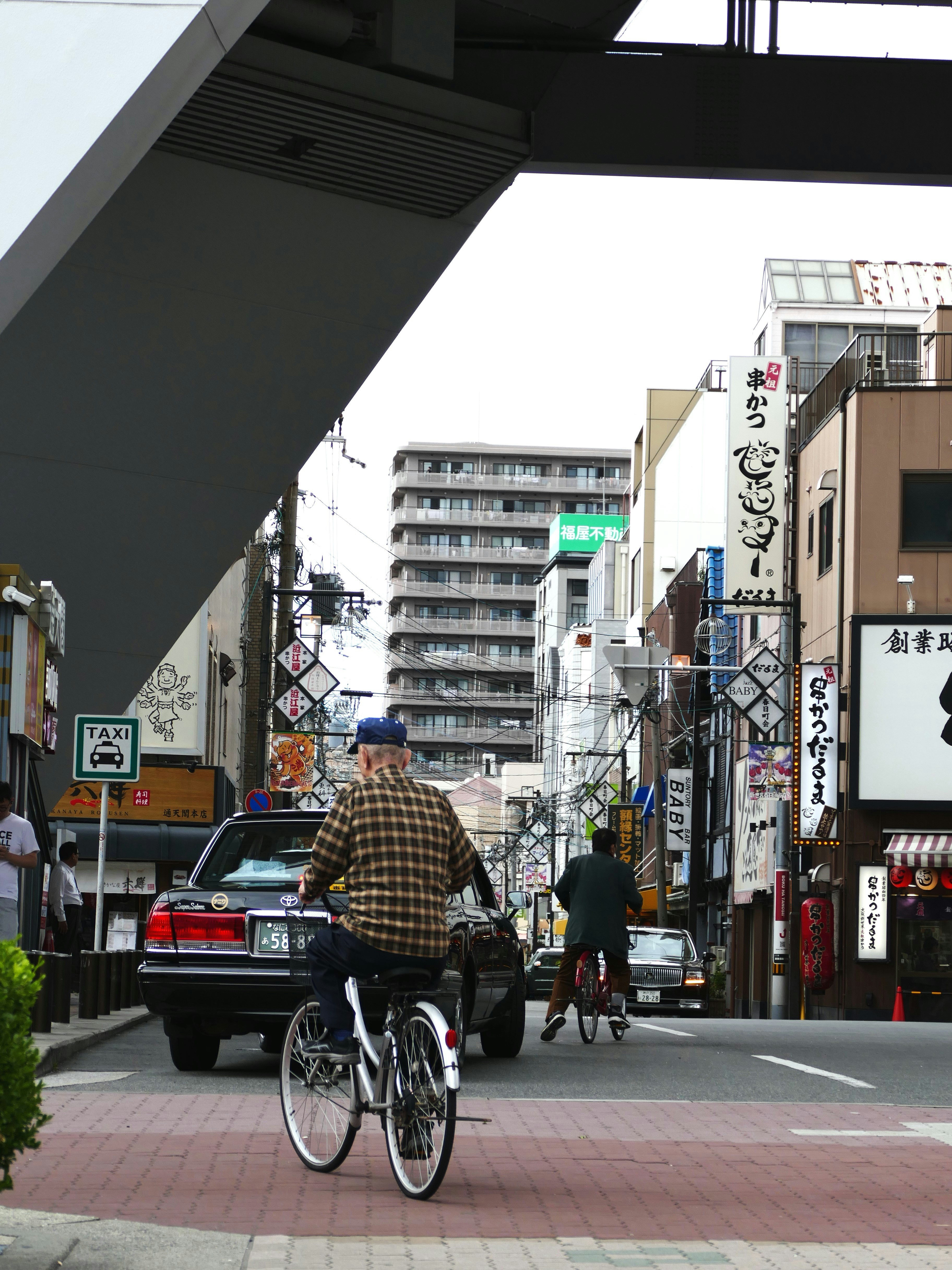 A man riding a bike down a street next to tall buildings
